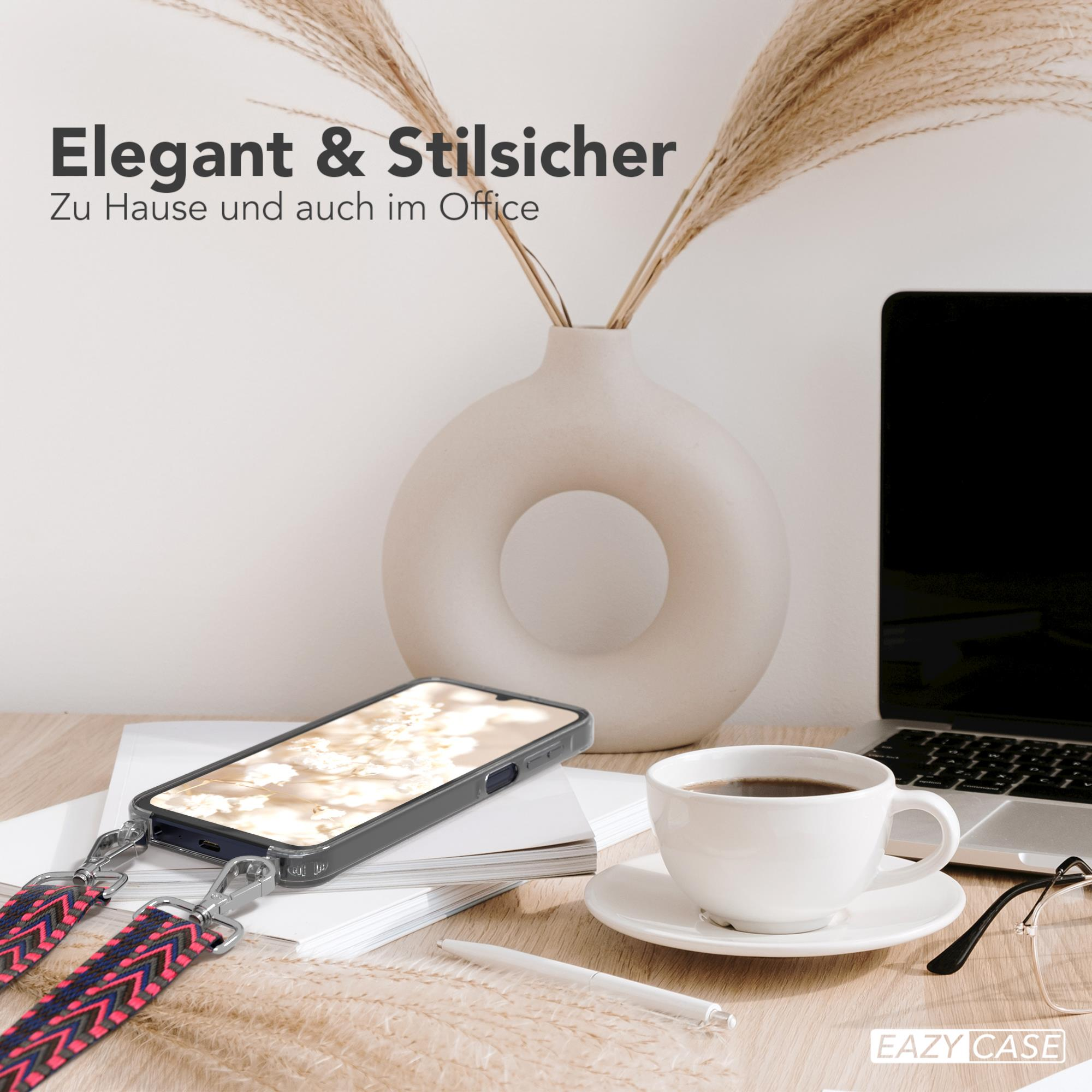 Smartphone auf Schreibtisch mit Hülle und Band, neben Laptop und Kaffee.
