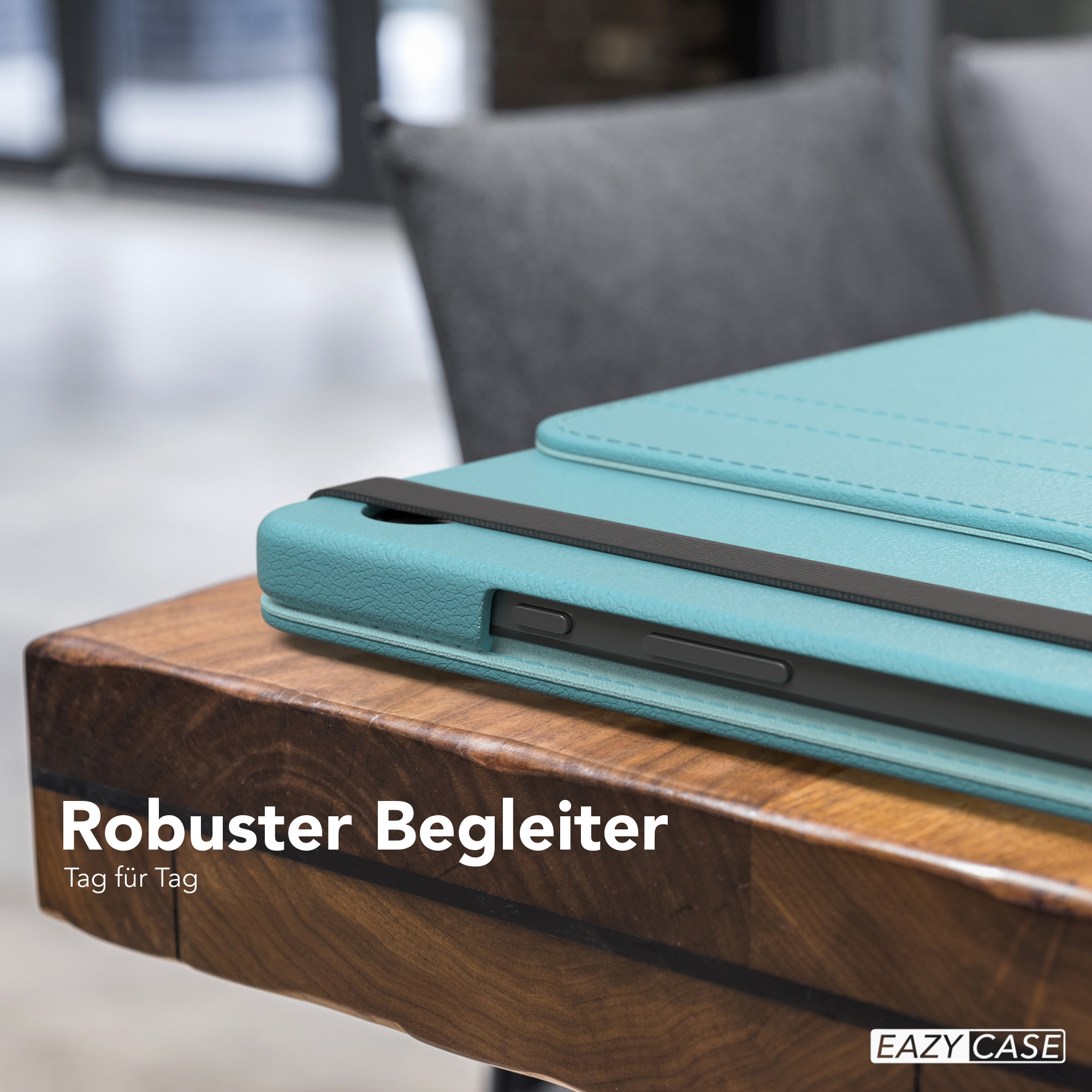 Tablet in einer tealfarbenen Hülle auf einem Holztisch, mit Text "Robuster Begleiter", ein grauer Stuhl im Hintergrund.