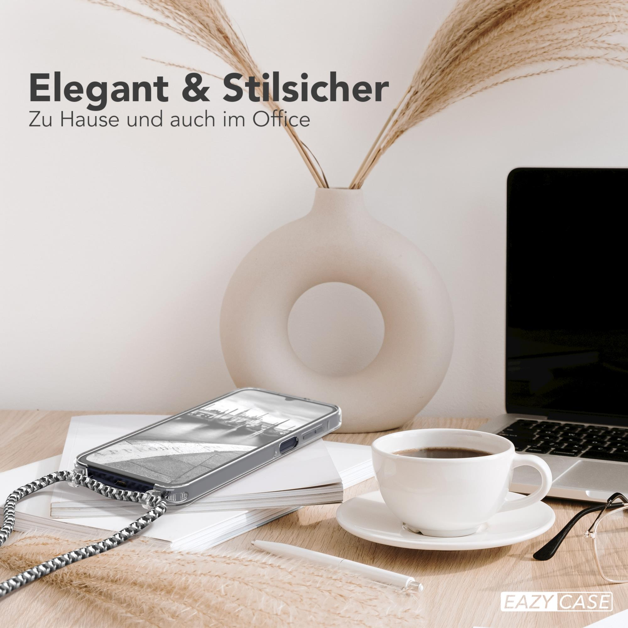 Ein Telefon in einer Hülle liegt auf einem Schreibtisch. Es gibt eine Kaffeetasse, einen Laptop und eine Vase mit Pflanzen.
