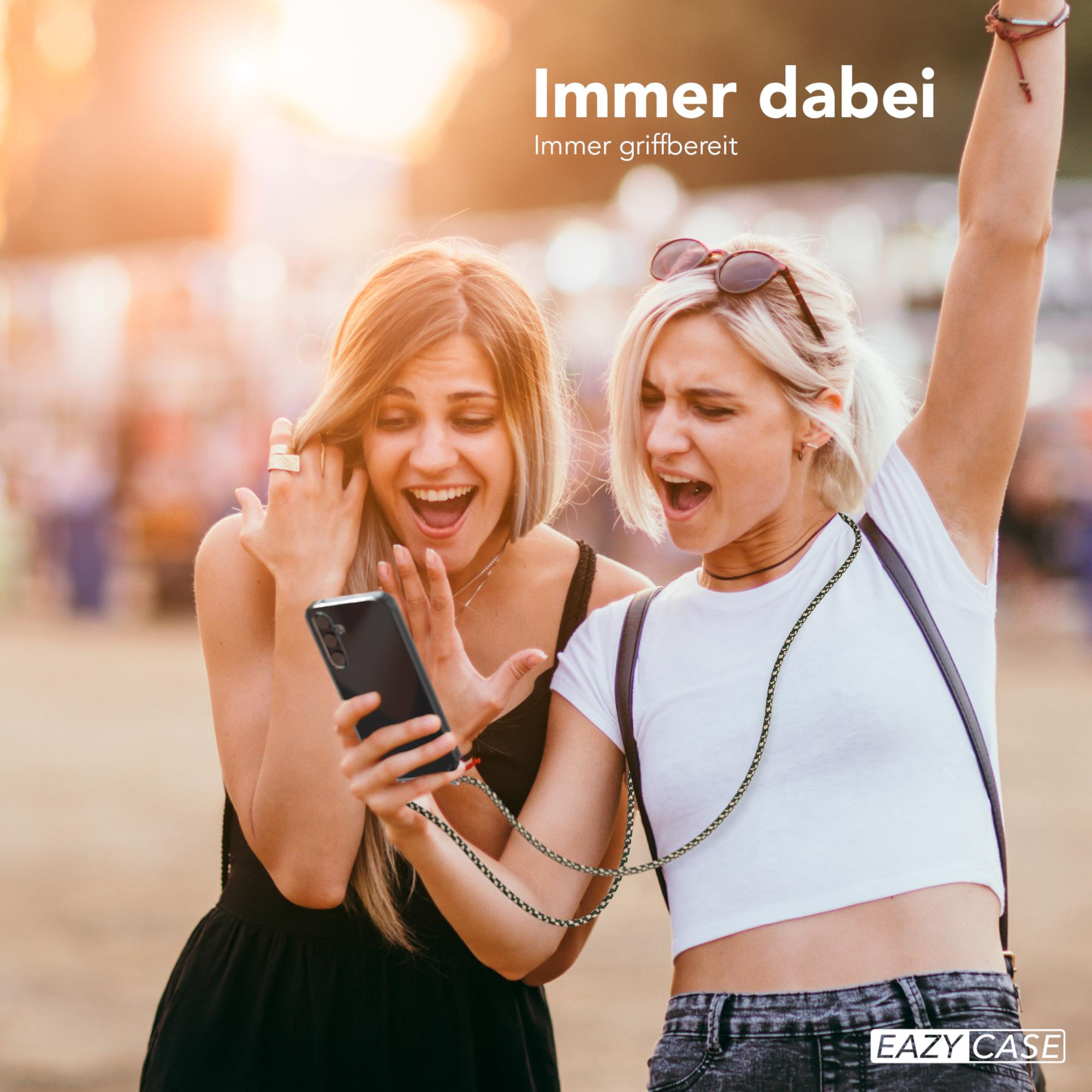 Zwei Frauen schauen auf ein Handy. Eine hebt aufgeregt den Arm.