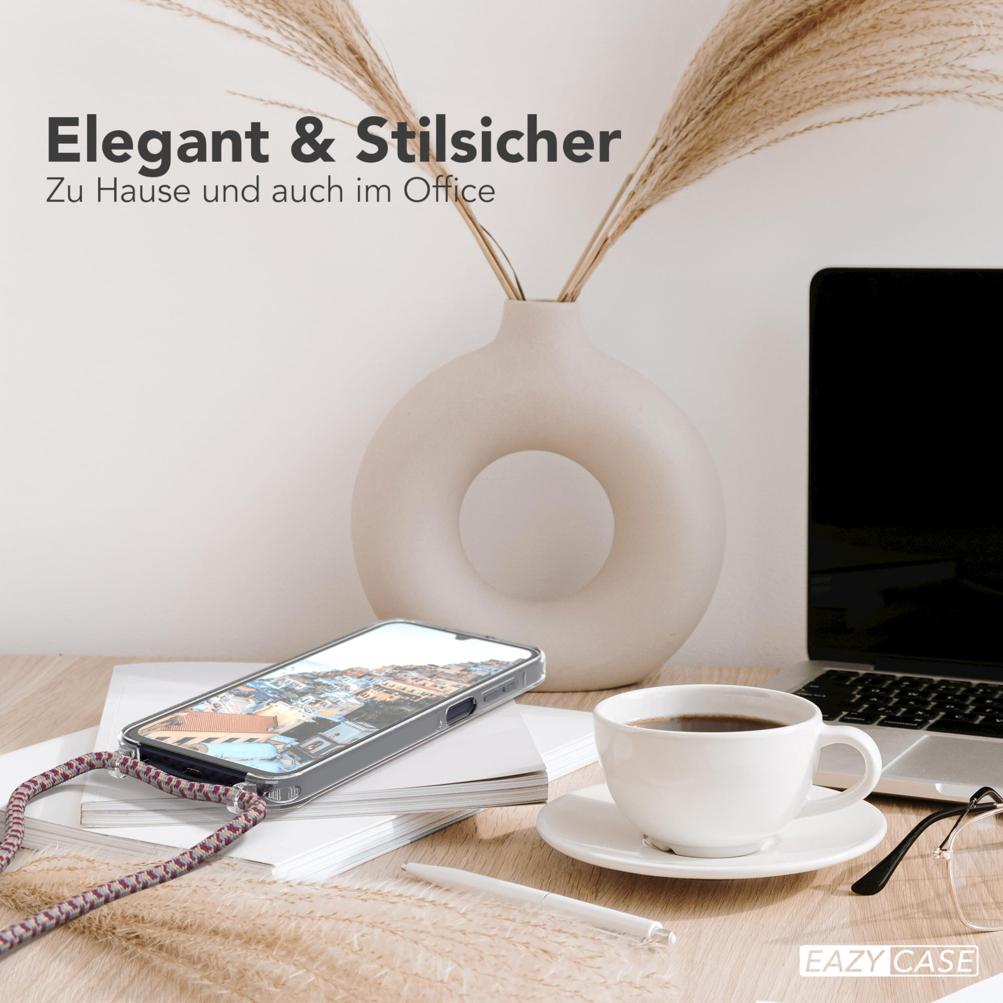 Telefon mit Hülle, Kaffee und Laptop auf einem Schreibtisch mit Vase und Pflanzen.