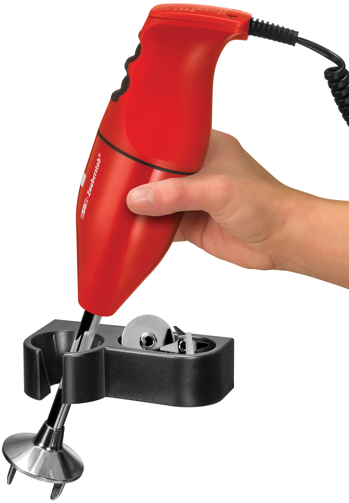 Eine Hand hält einen roten Stabmixer mit schwarzer Basis. Der Mixer ist eingesteckt. Der Mixer ist mit "ESGE Zauberstab" beschriftet.