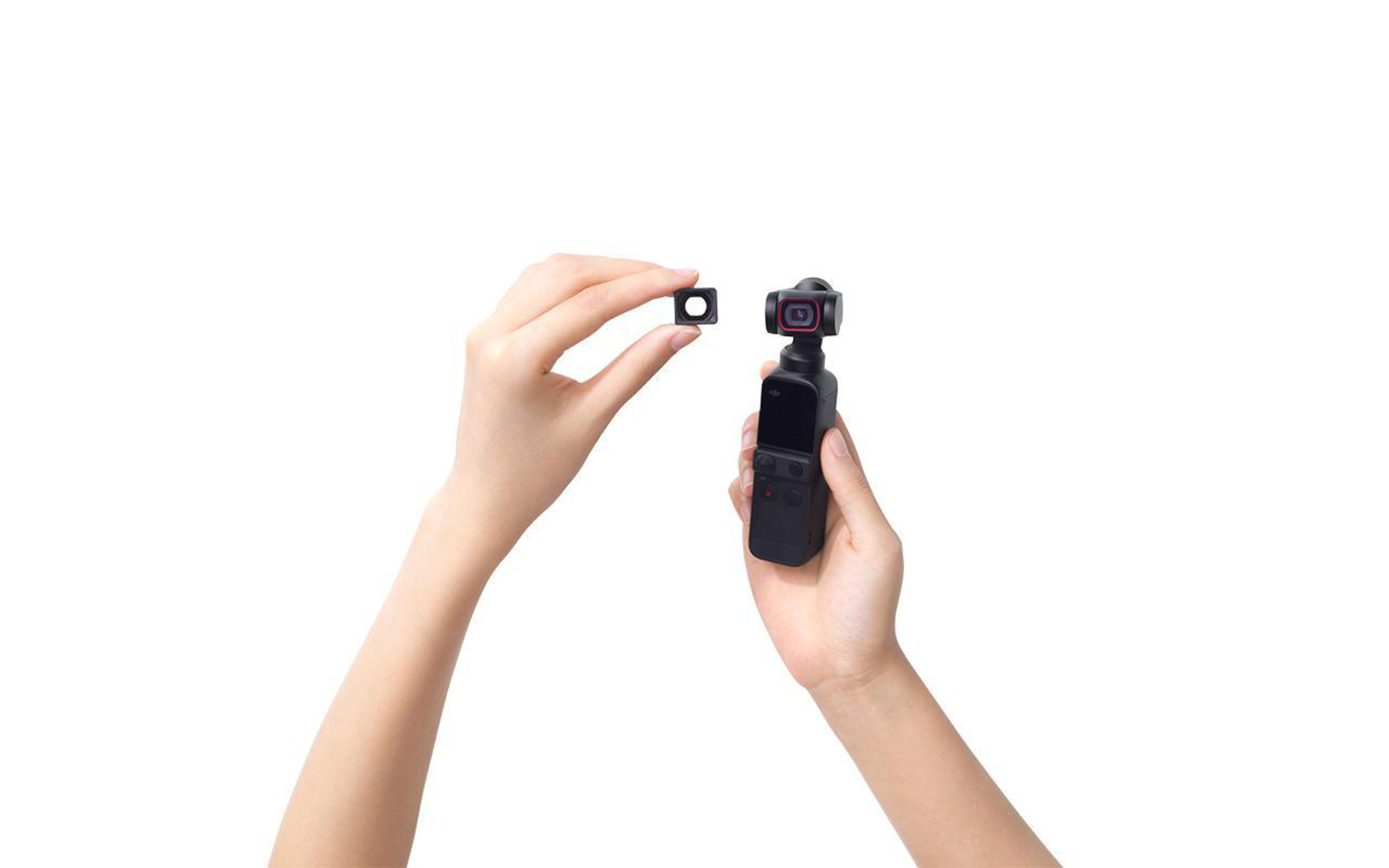 Mani che tengono una piccola fotocamera nera e un filtro quadrato, su sfondo bianco.