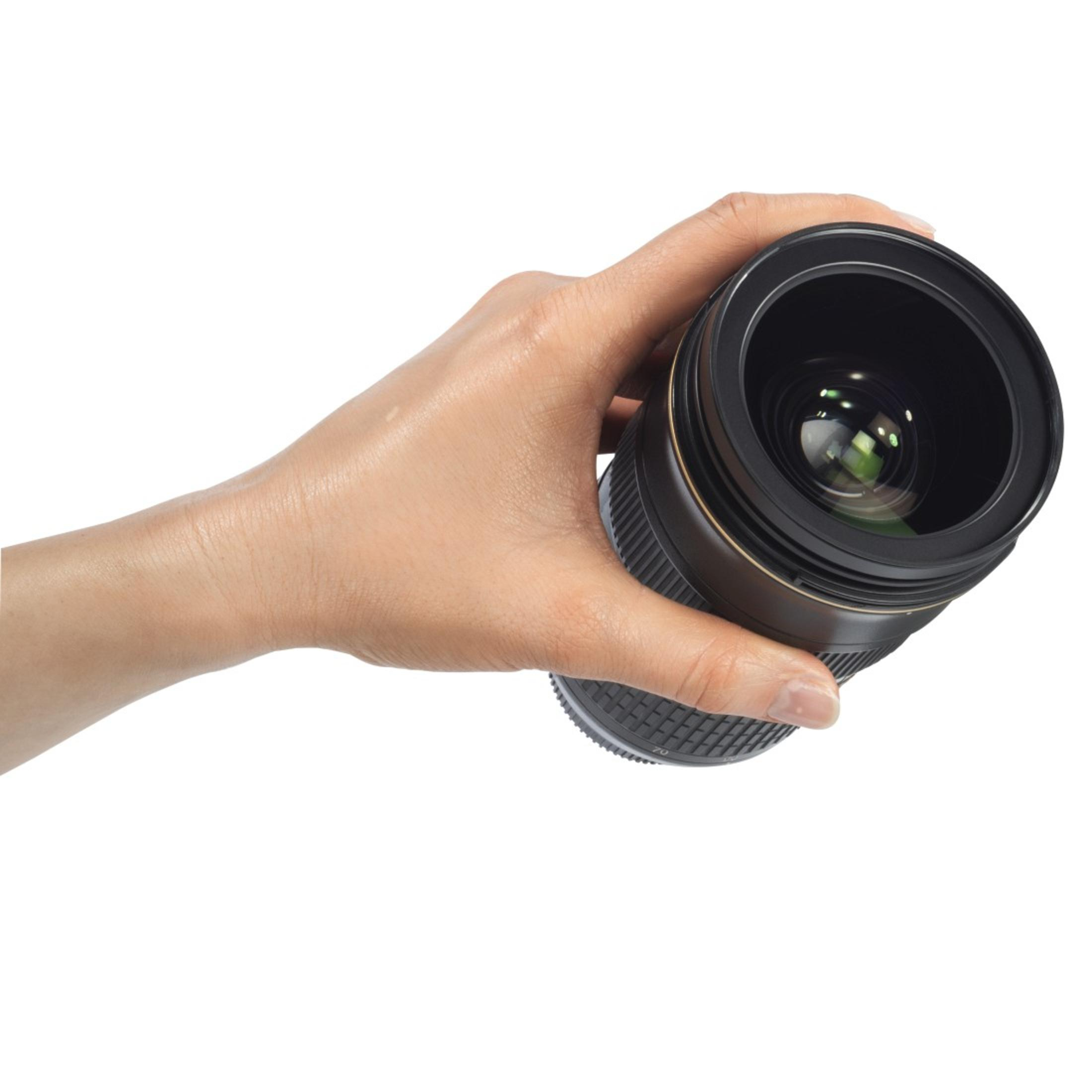 Ręka trzymająca czarny obiektyw aparatu.