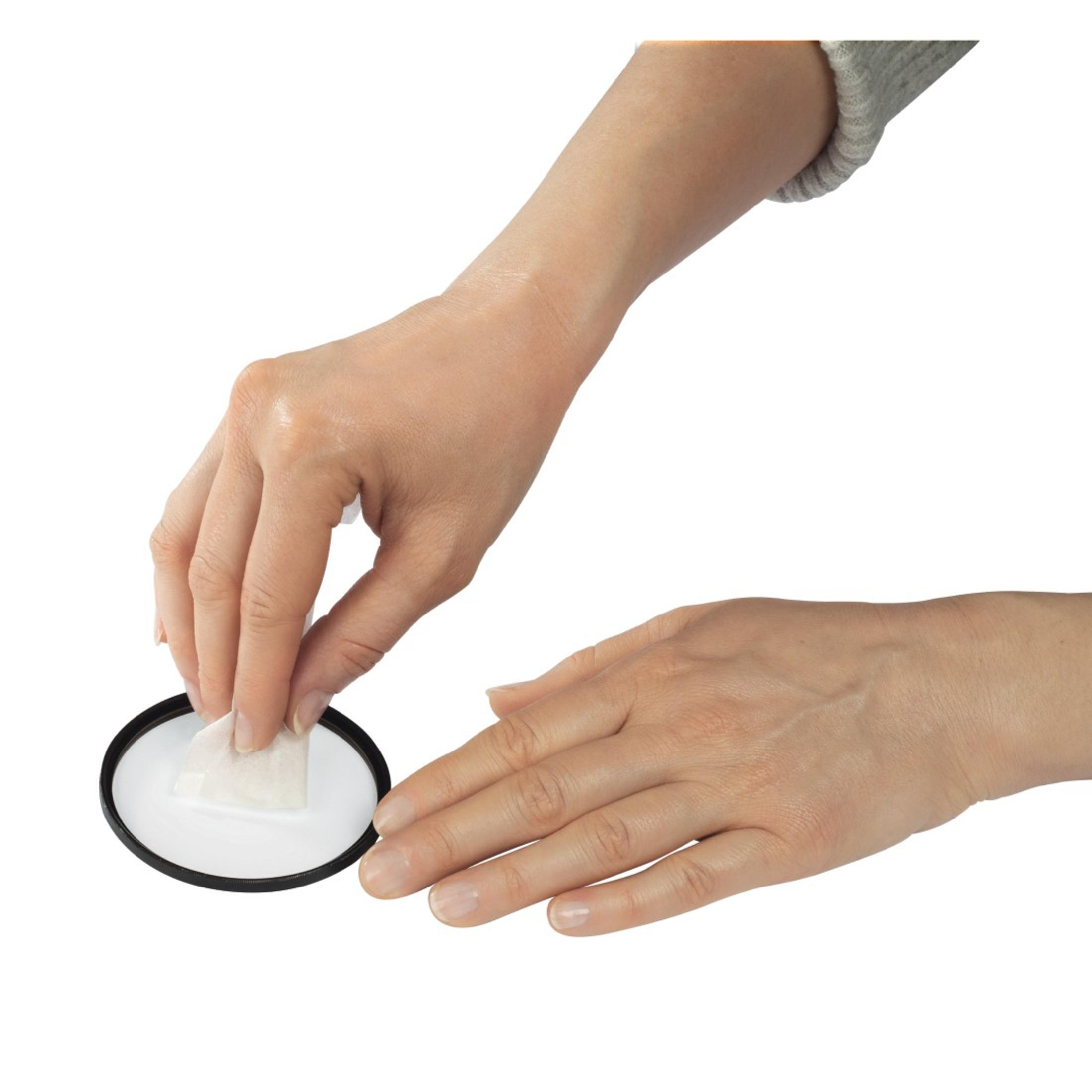 Dwie ręce czyszczą czarny filtr. Używana jest biała chusteczka.