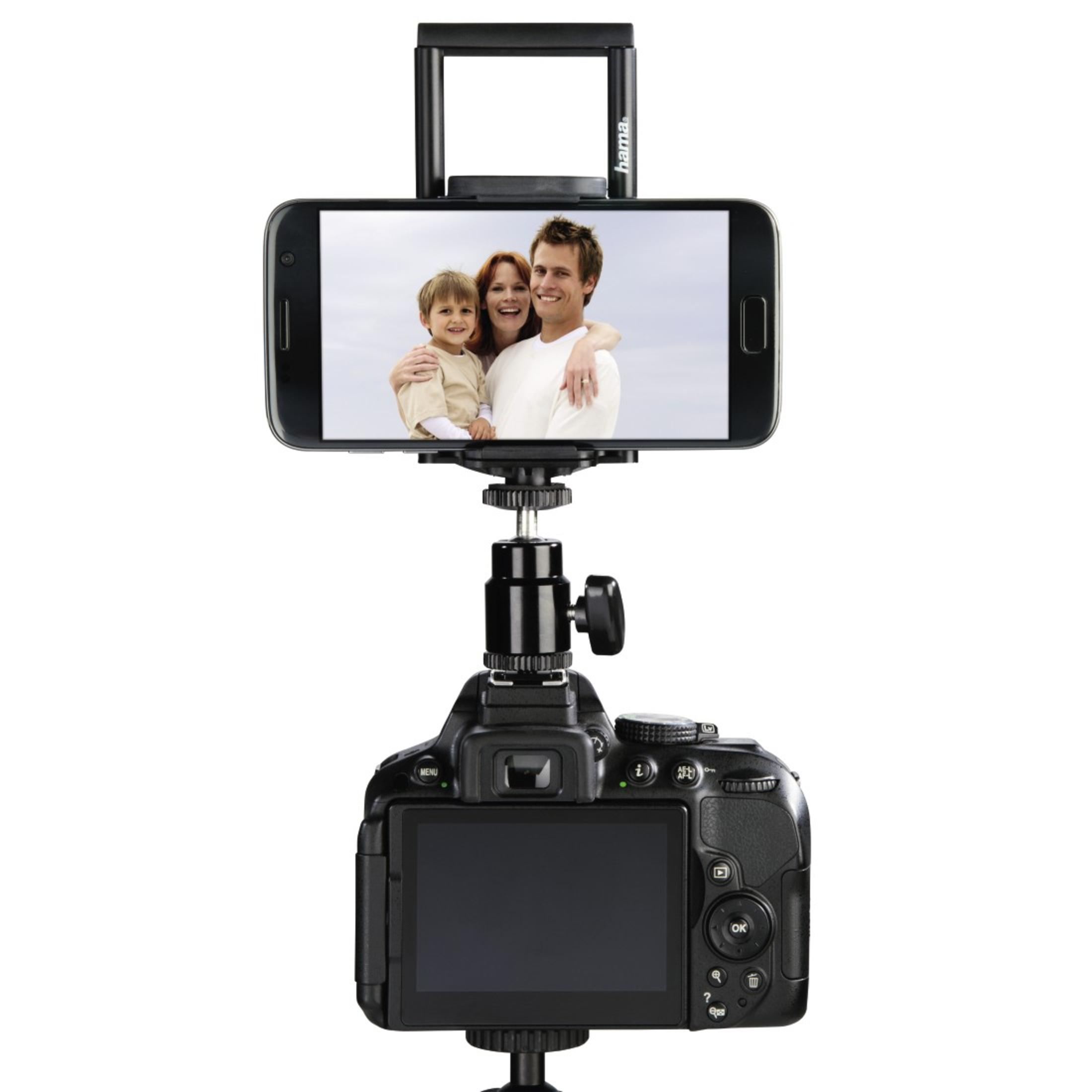 Eine Kamera mit einem darauf montierten Telefon, das ein Familienfoto zeigt, auf weißem Hintergrund.
