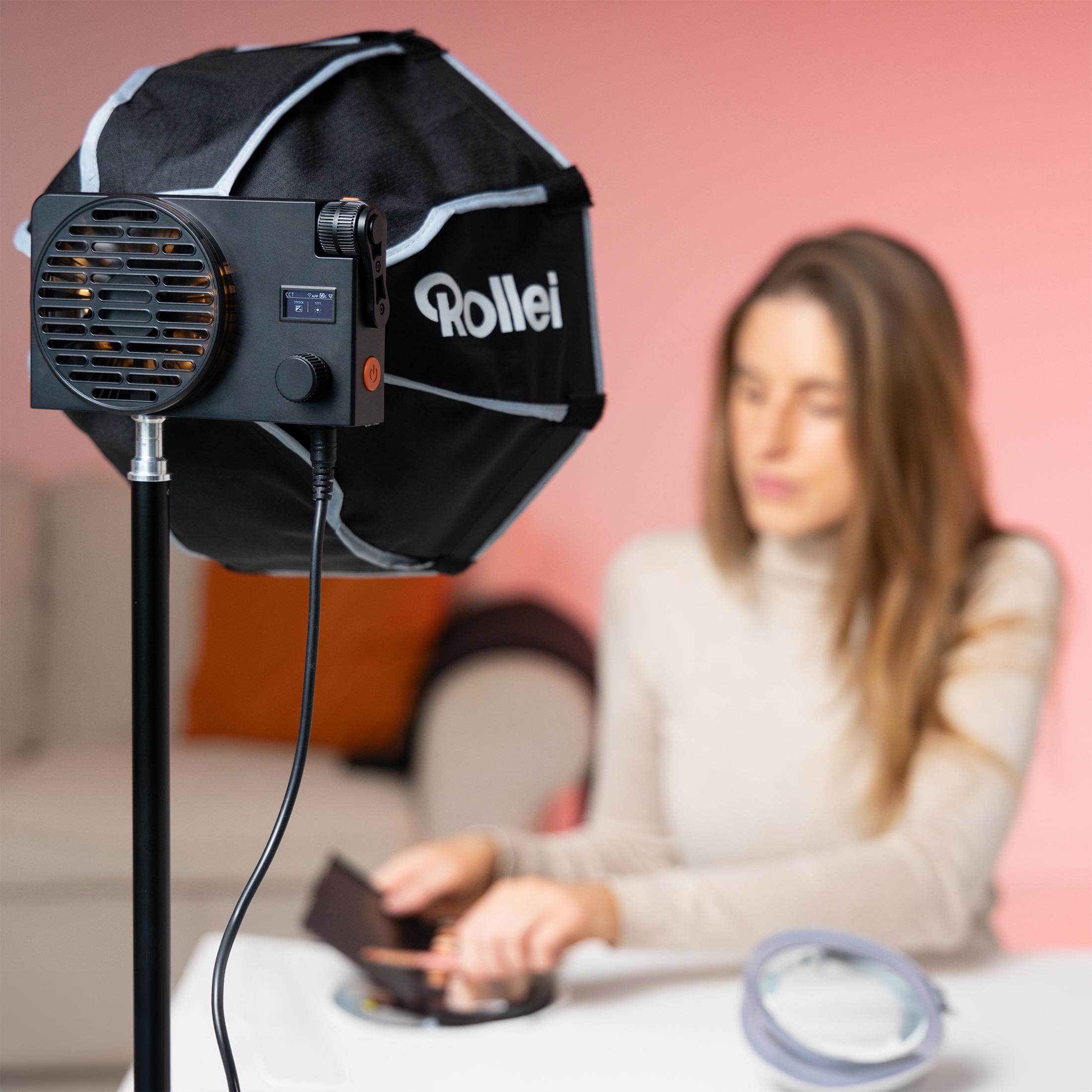 Studio-Setup mit Softbox und verschwommener Frau im Hintergrund. Schwarz und rot.