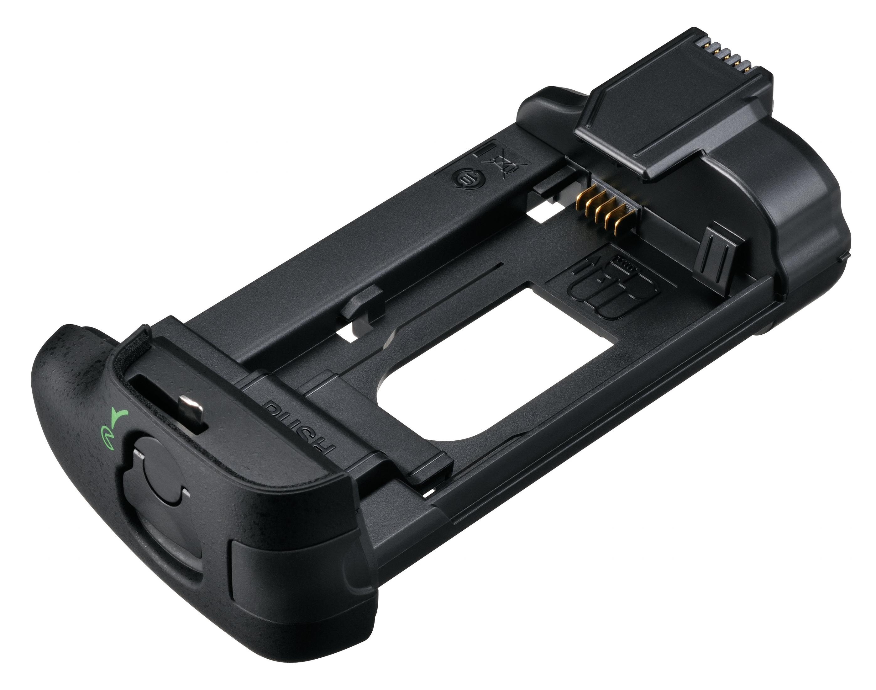 Ein schwarzer Kamera-Batteriegriff mit grünem Knopf. Der Griff liegt auf einer weißen Oberfläche.