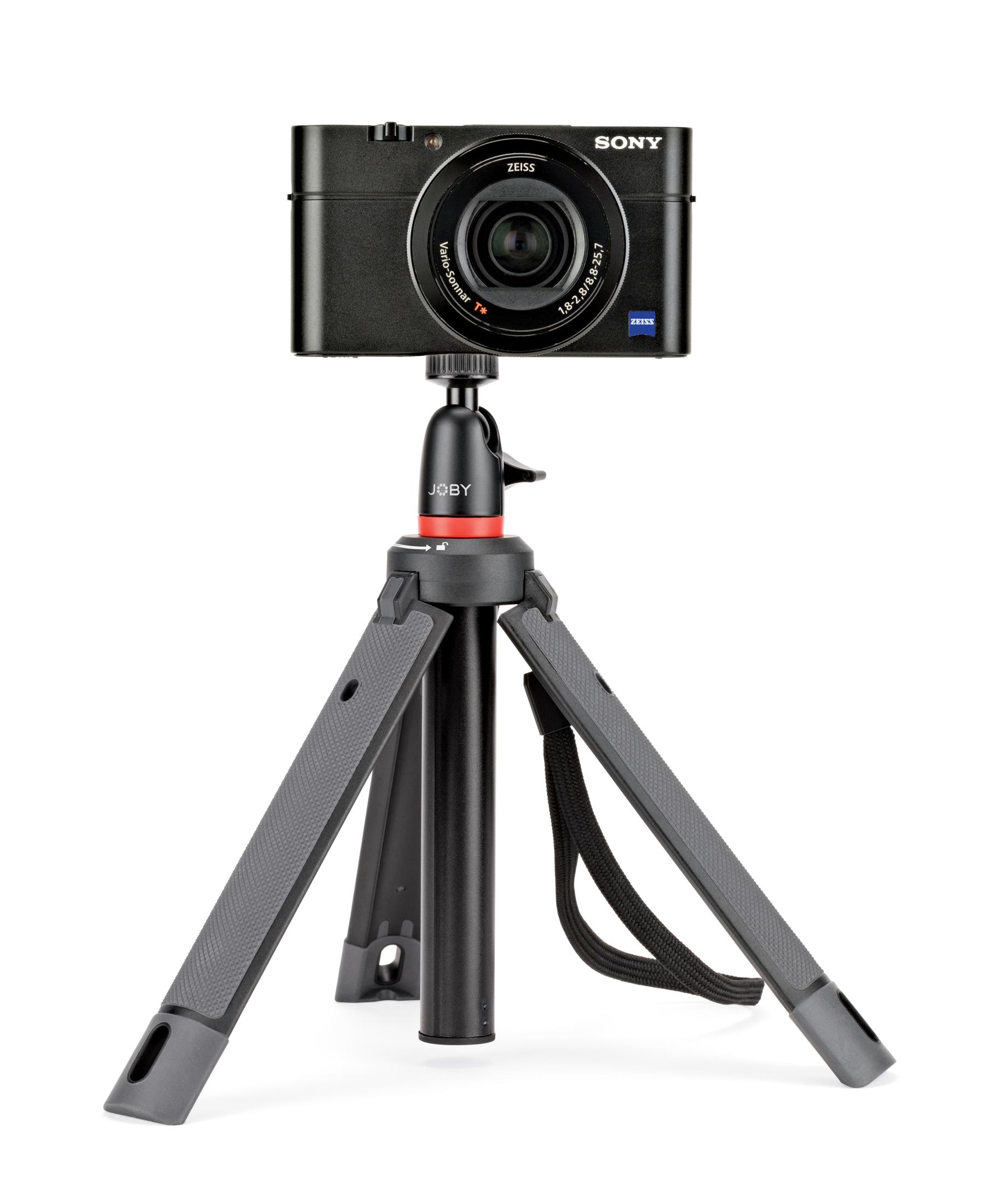 Black camera on a tripod, white background.