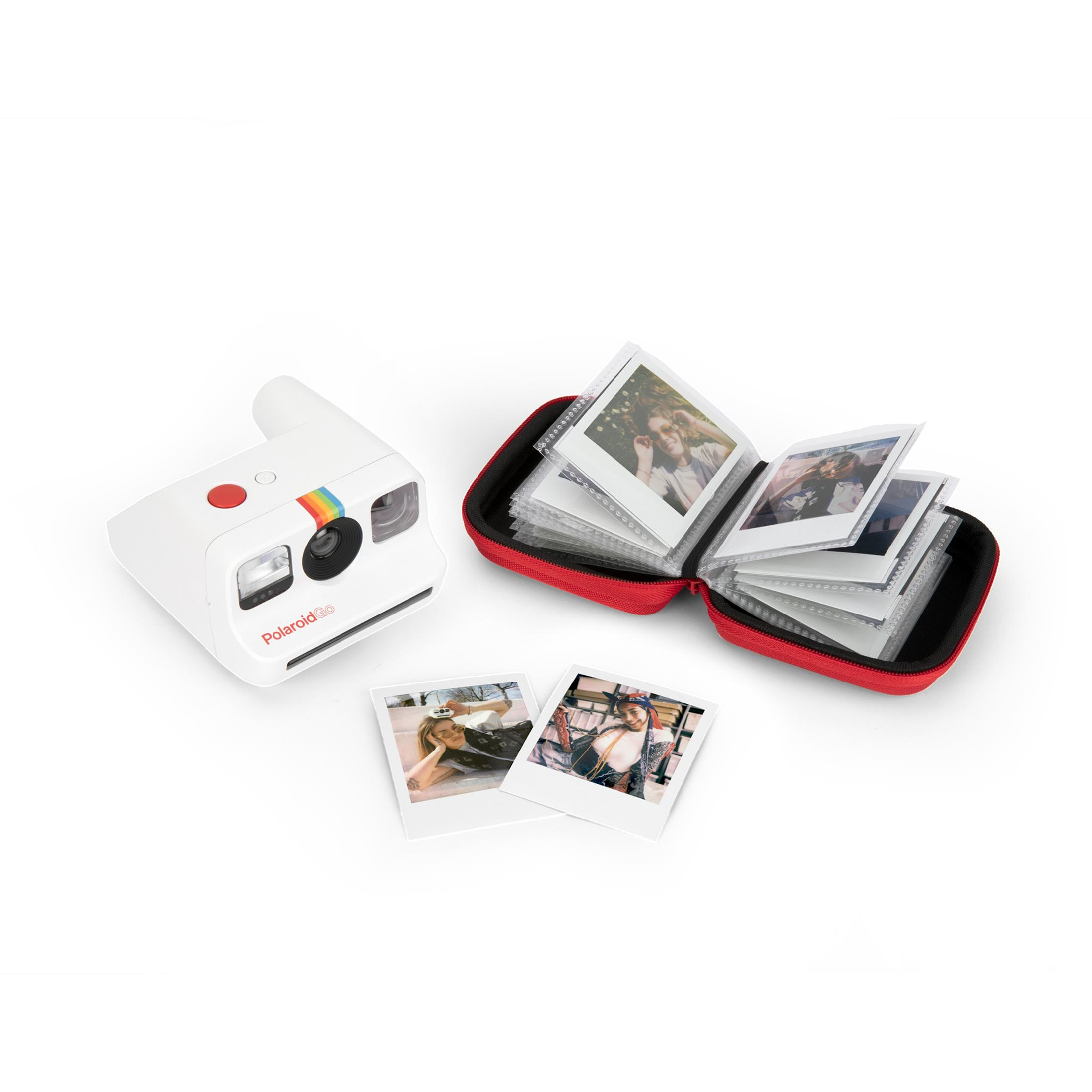 Weiße Polaroid-Kamera mit Fotos in einem roten Etui und zwei losen Fotos.