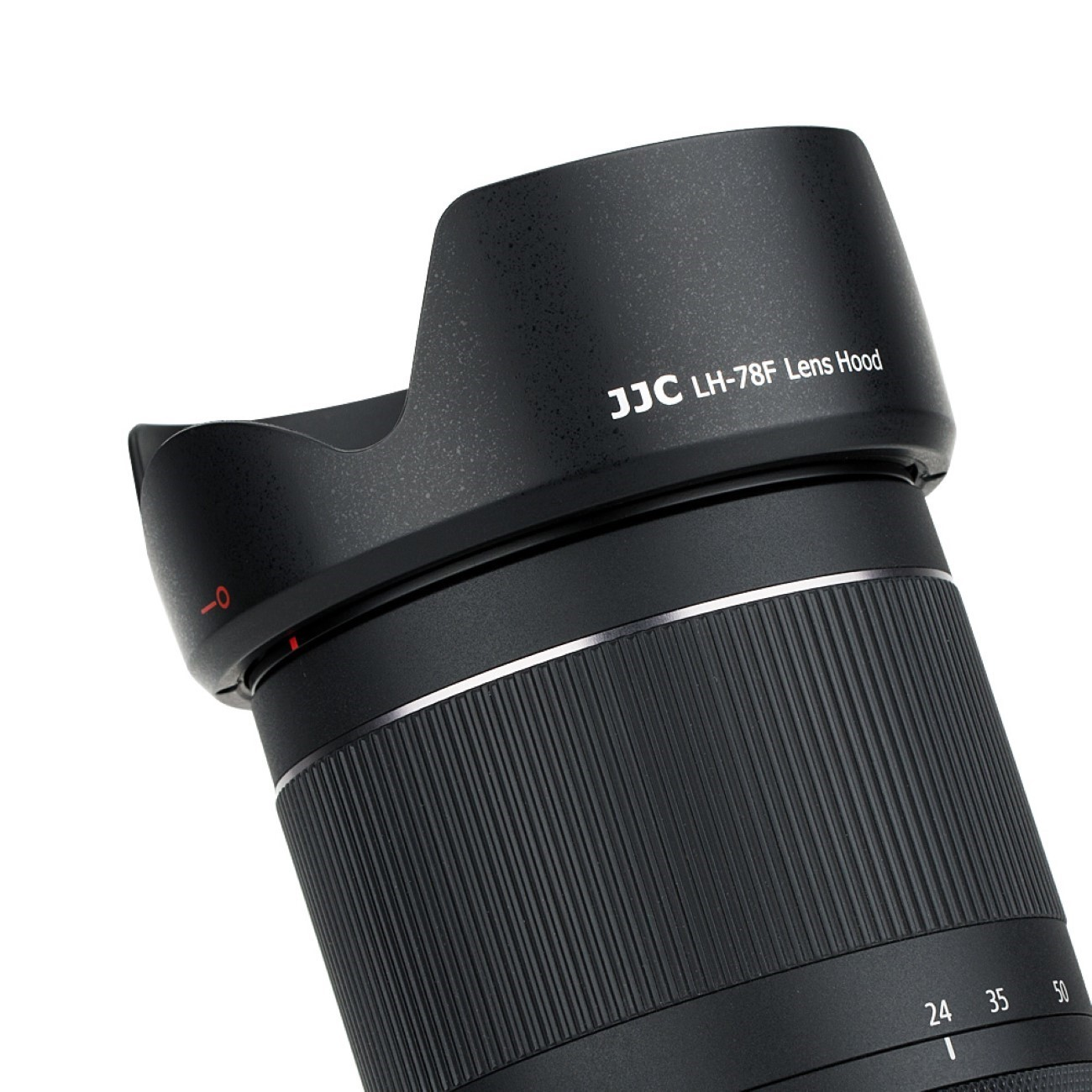 Eine schwarze Gegenlichtblende an einem schwarzen Kameraobjektiv befestigt. Auf der Blende steht 'JJC LH-78F Lens Hood'.
