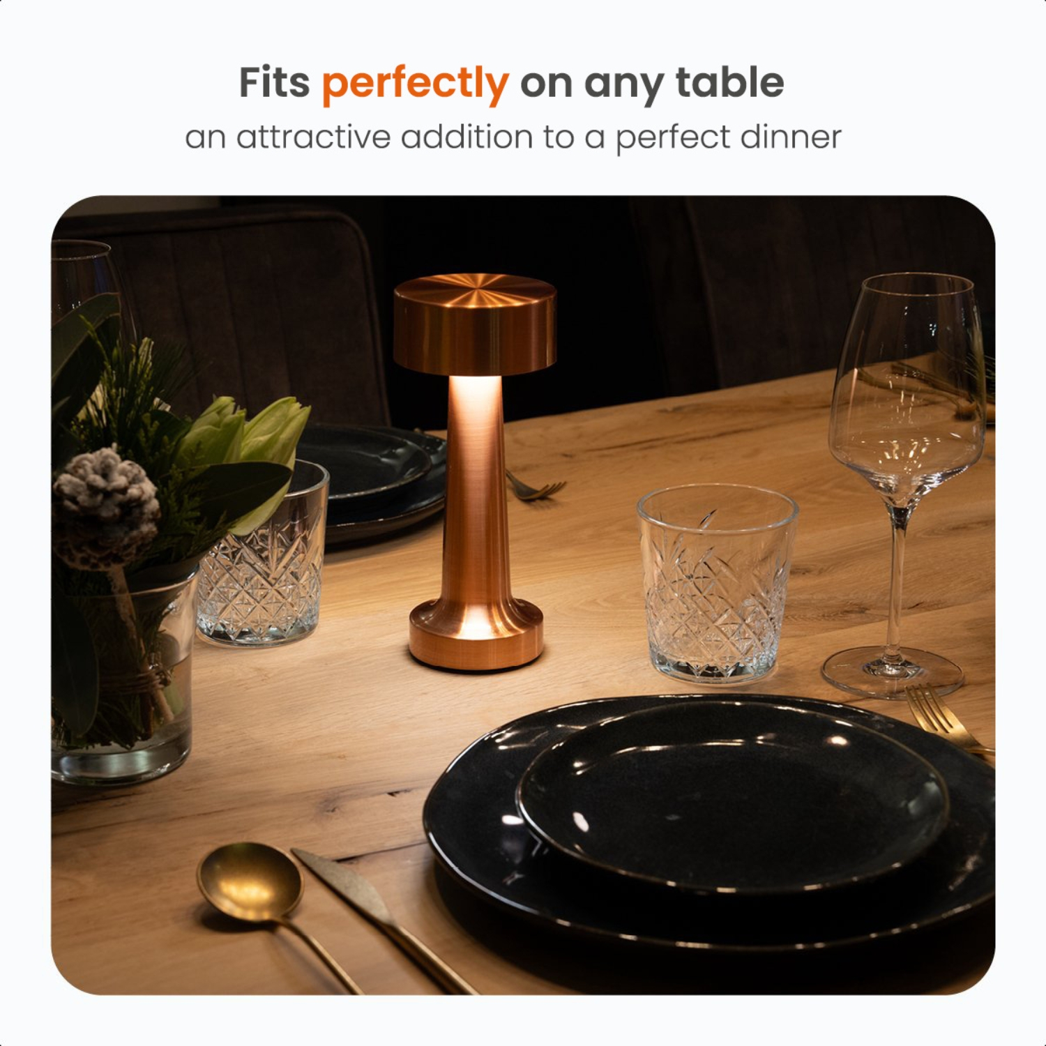 Table setting with a copper lamp, glasses, plates, and silverware.