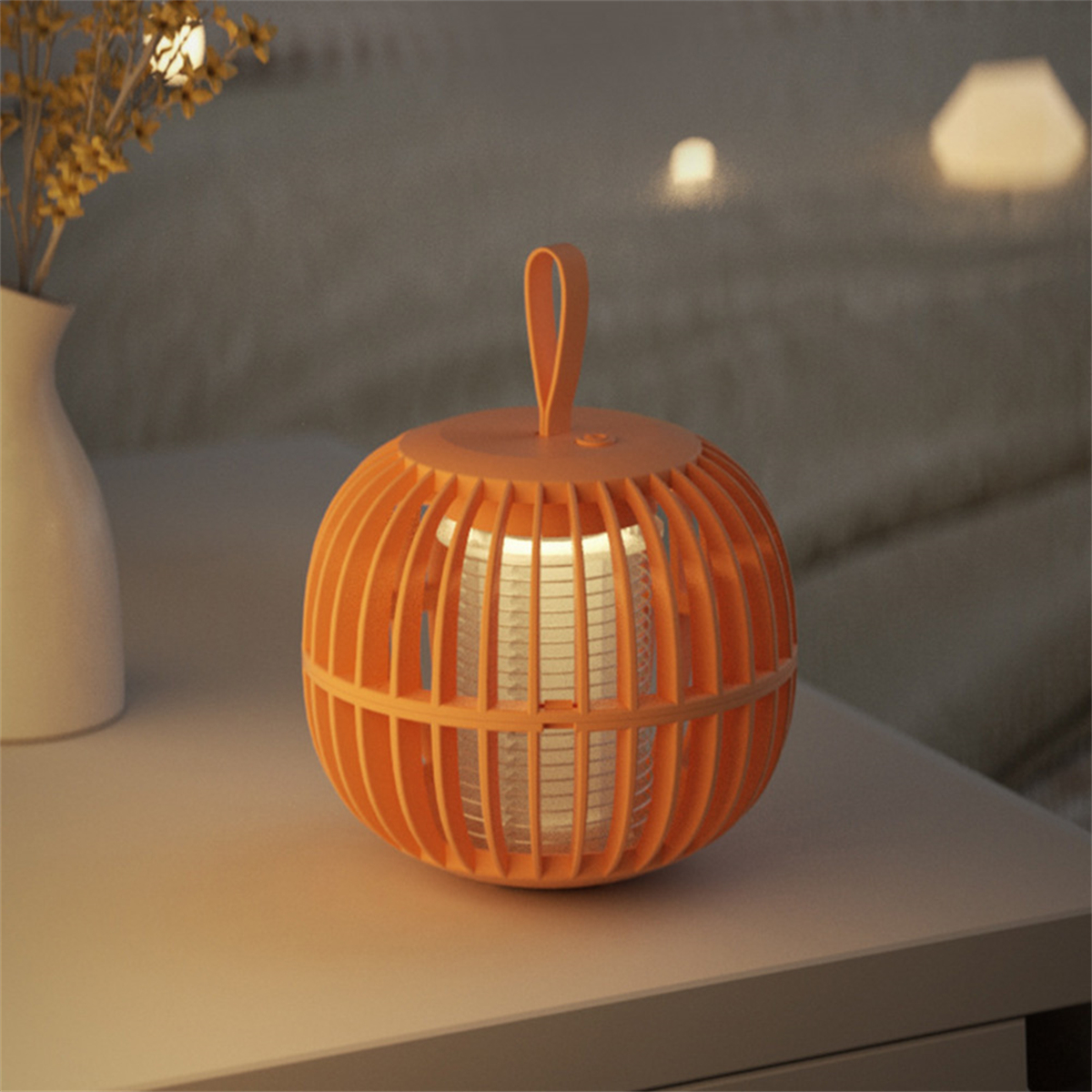 Orangefarbene Mückentötungslampe auf einem Tisch, mit weichem Licht und einer weißen Vase.