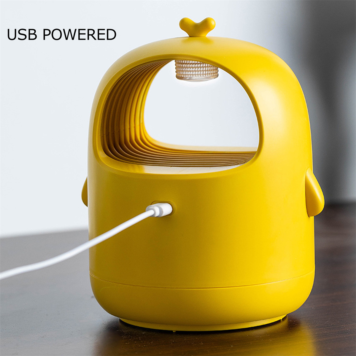 Gelber Insektenvernichter mit eingestecktem USB-Kabel, vor unscharfem Hintergrund.