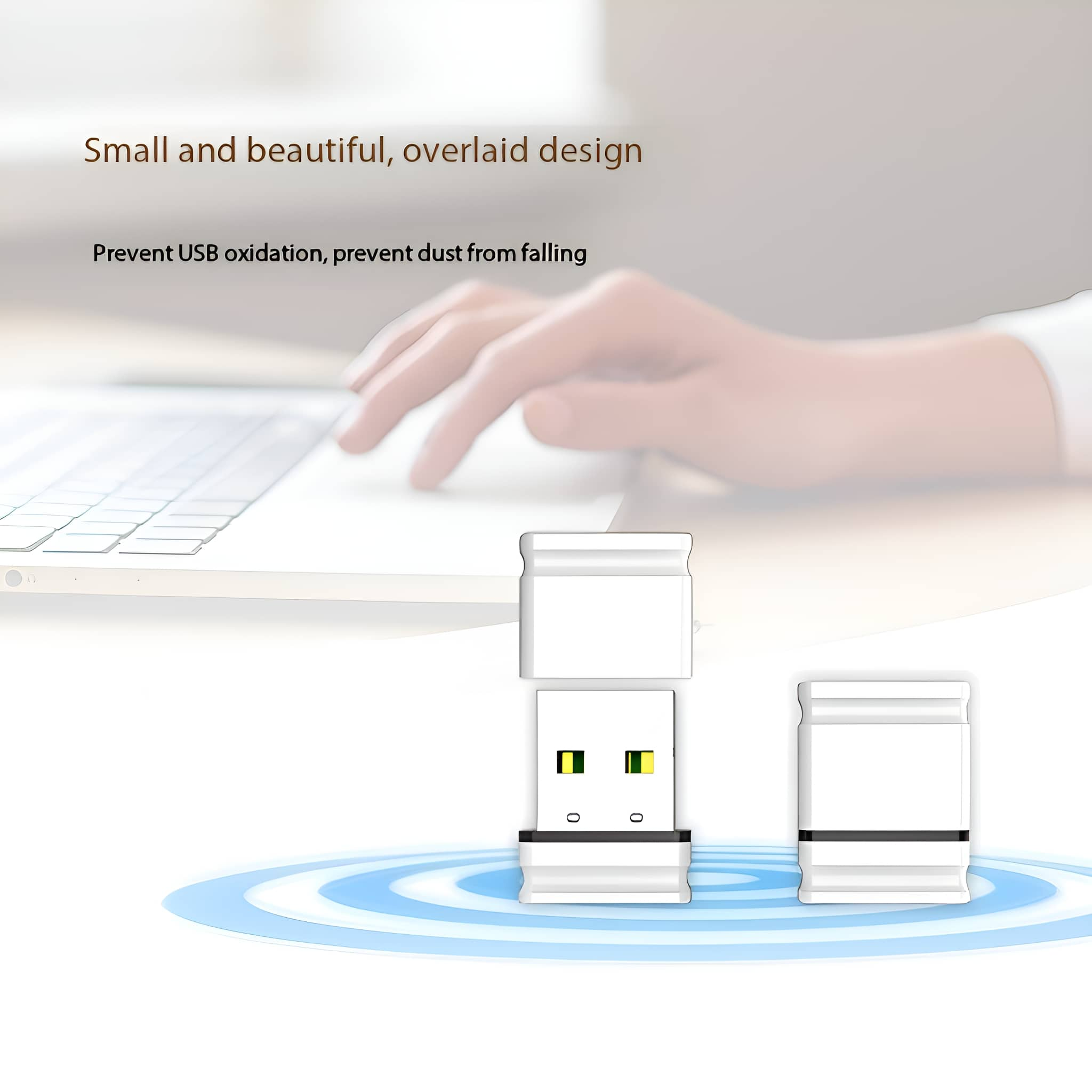 Zwei weiße USB-Adapter, einer in den anderen eingesteckt, mit einer Hand, die im Hintergrund einen Laptop benutzt.