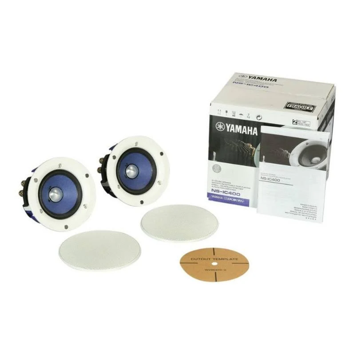 Dos altavoces blancos, dos cubiertas de altavoz y una caja con el logo de Yamaha. También hay una plantilla de recorte.