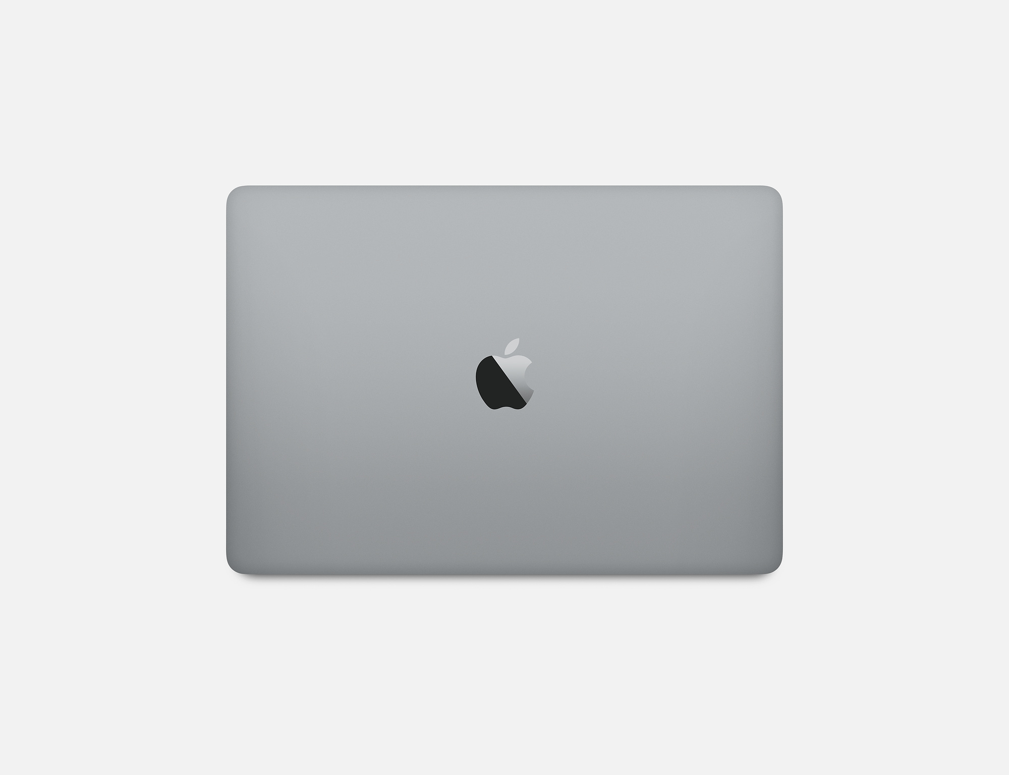 Srebrny laptop z logo Apple. Widok z góry, na białej powierzchni.