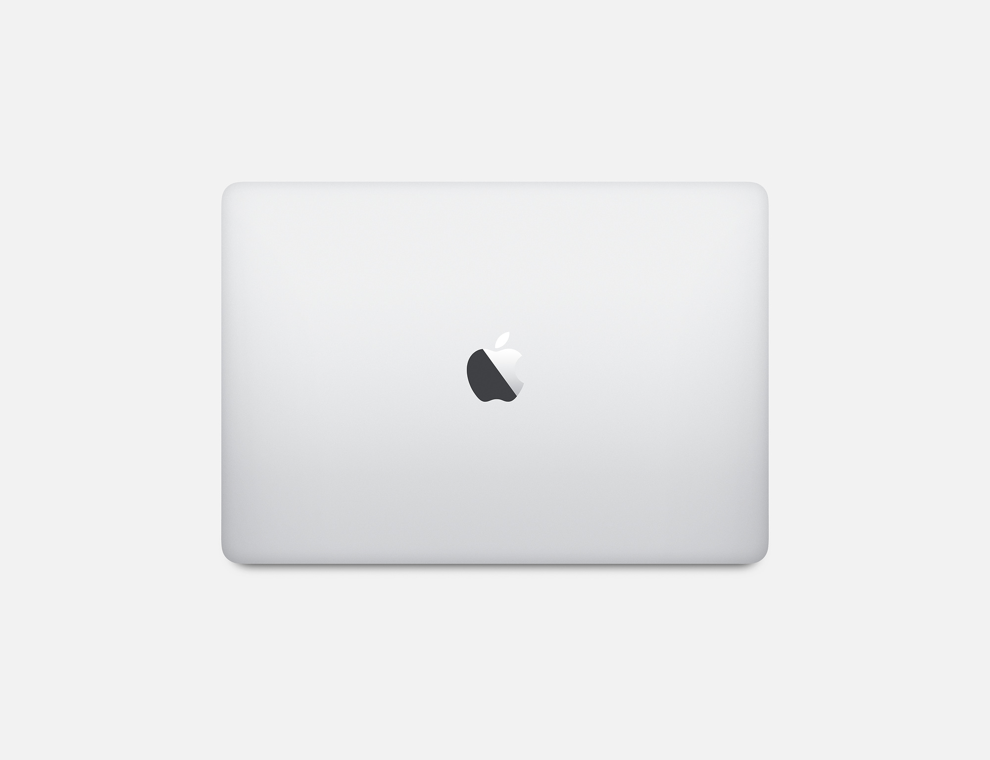 Srebrny laptop z logo Apple widocznym na pokrywie. Białe tło.