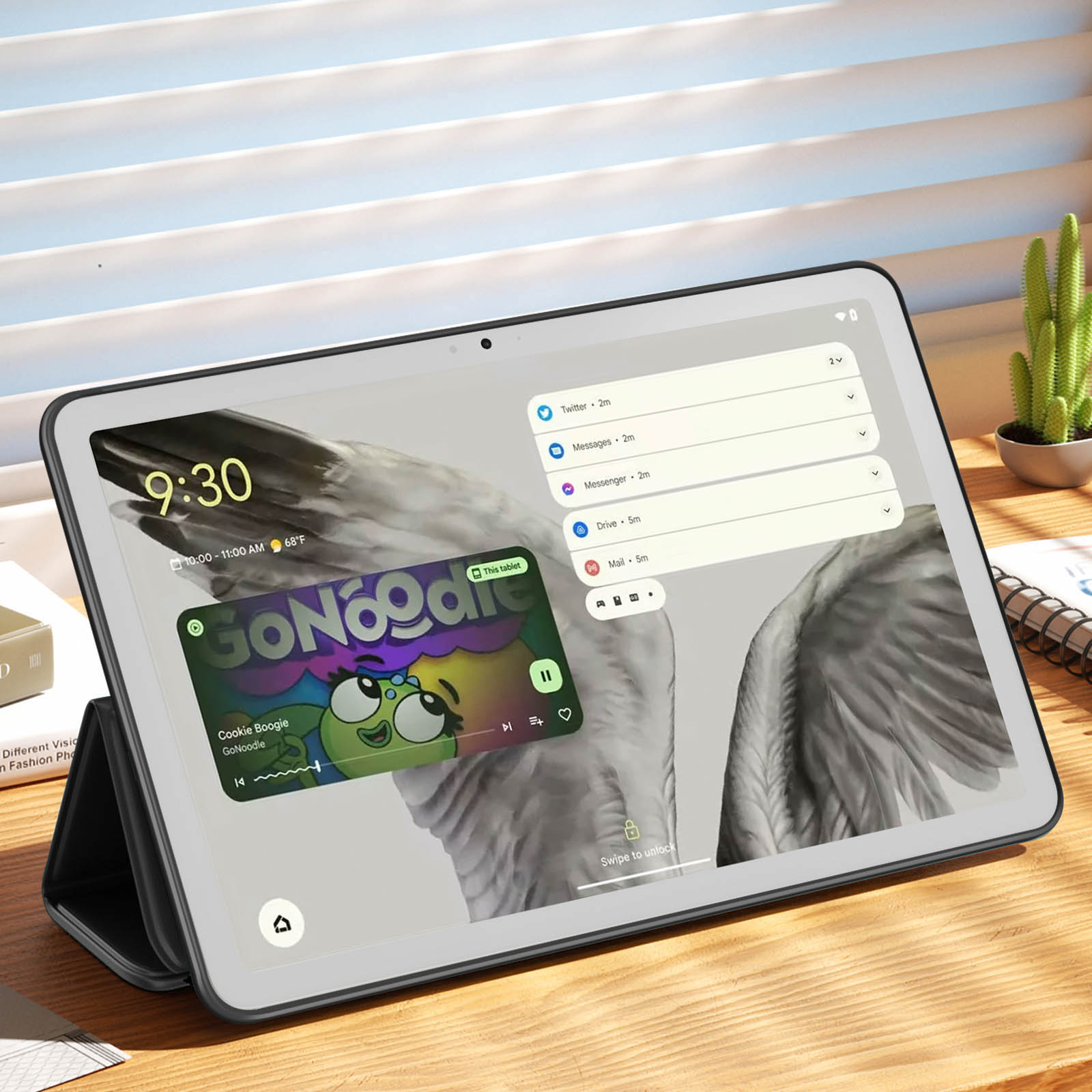 Tablet che mostra contenuti, con un supporto nero e un cactus sullo sfondo.