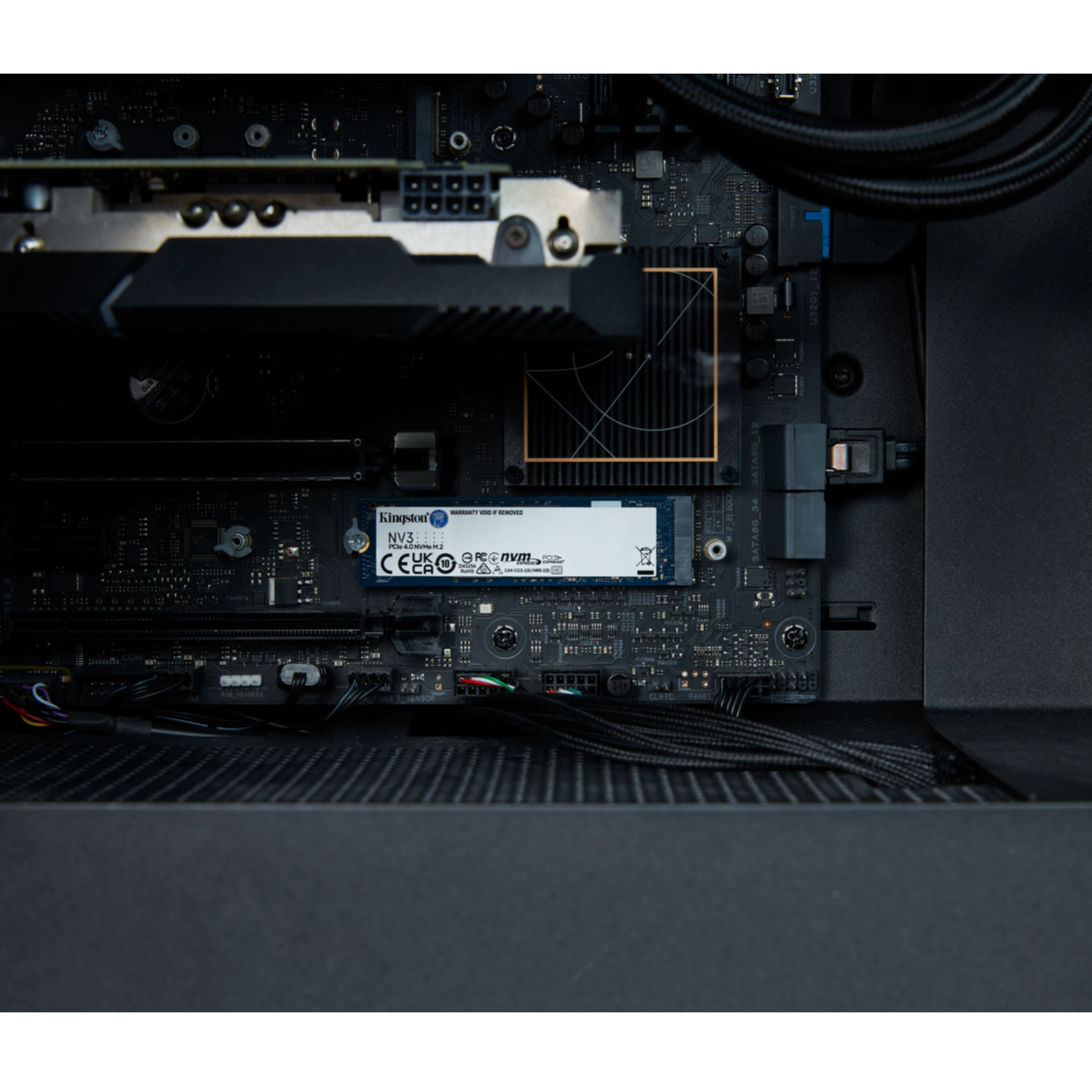 Wewnętrzne komponenty komputera, w tym dysk SSD Kingston NV3 i kable.