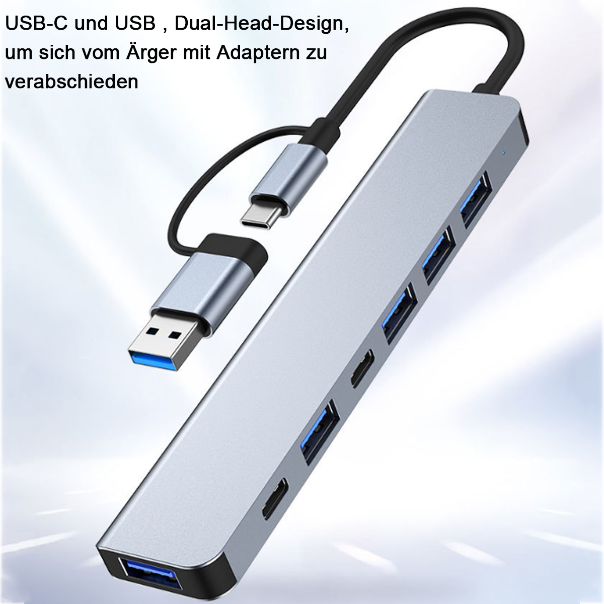 Ein silberner USB-Hub mit mehreren Anschlüssen und USB-C- und USB-Anschlüssen. Er liegt auf weißem Hintergrund mit schwarzem Kabel.