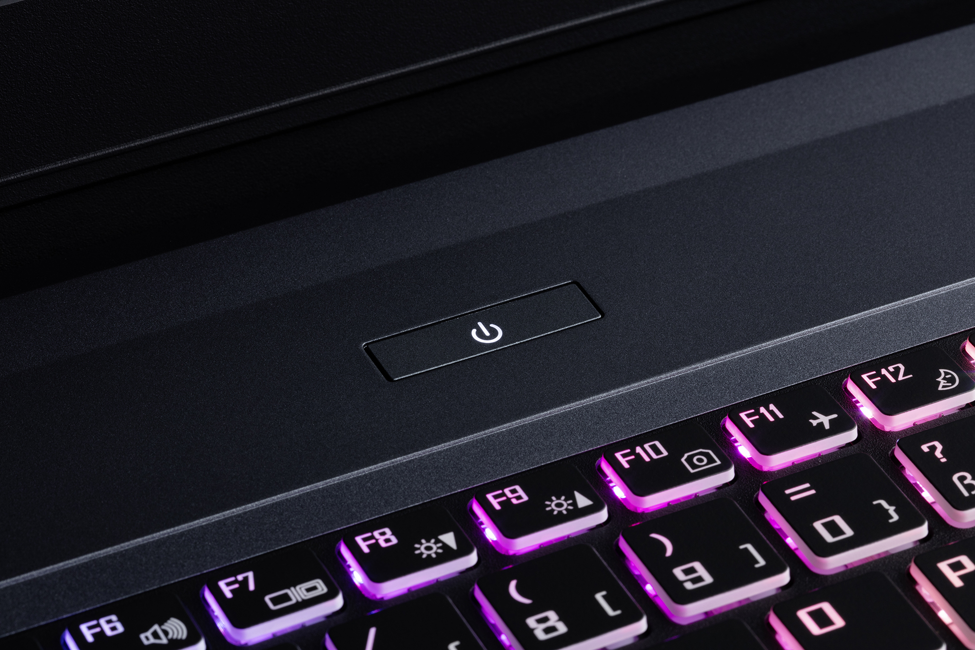 Un primo piano di una tastiera di un laptop con il pulsante di accensione illuminato.
