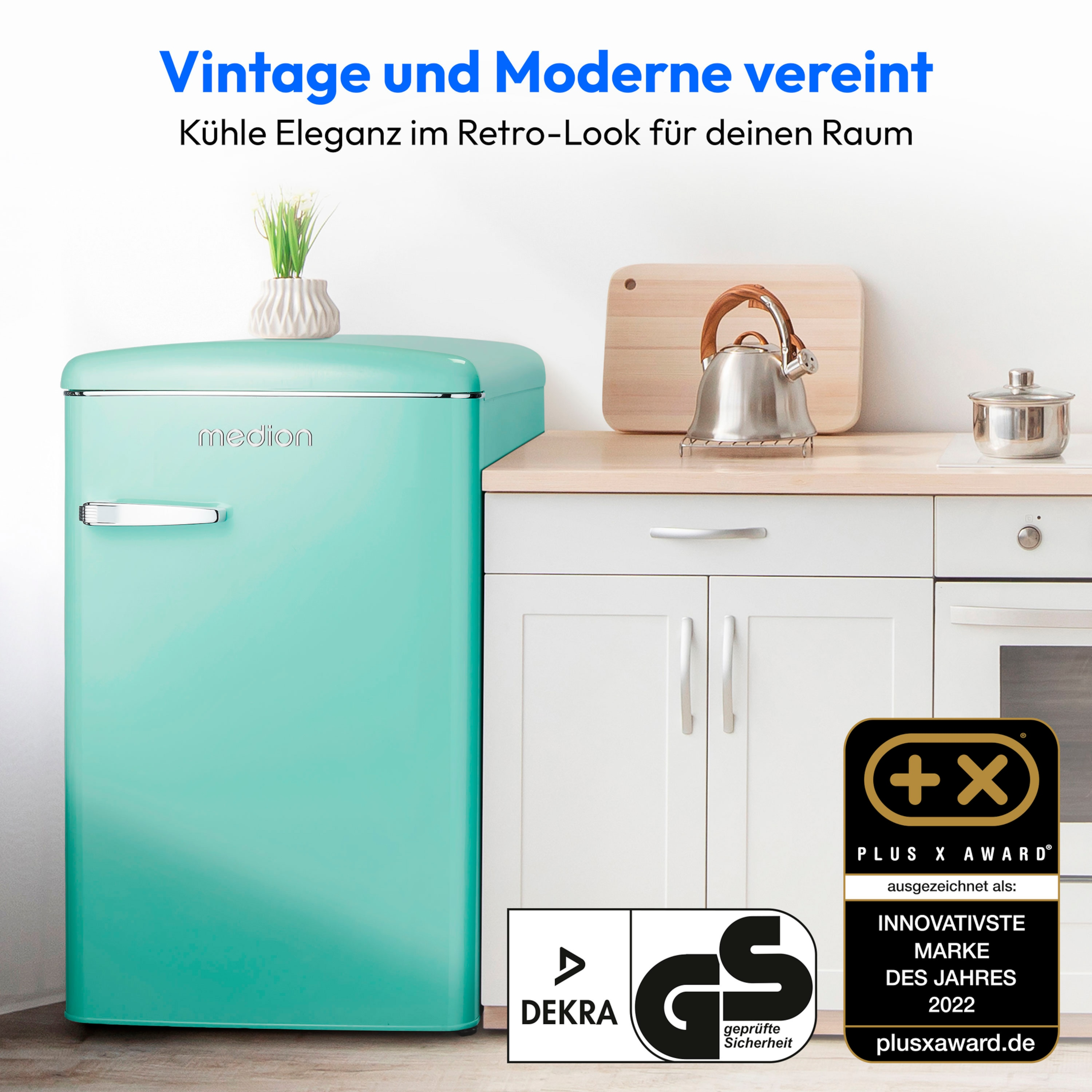 Türkisfarbener Kühlschrank im Retro-Stil mit kleiner Pflanze. Küchenumgebung mit Auszeichnungen.