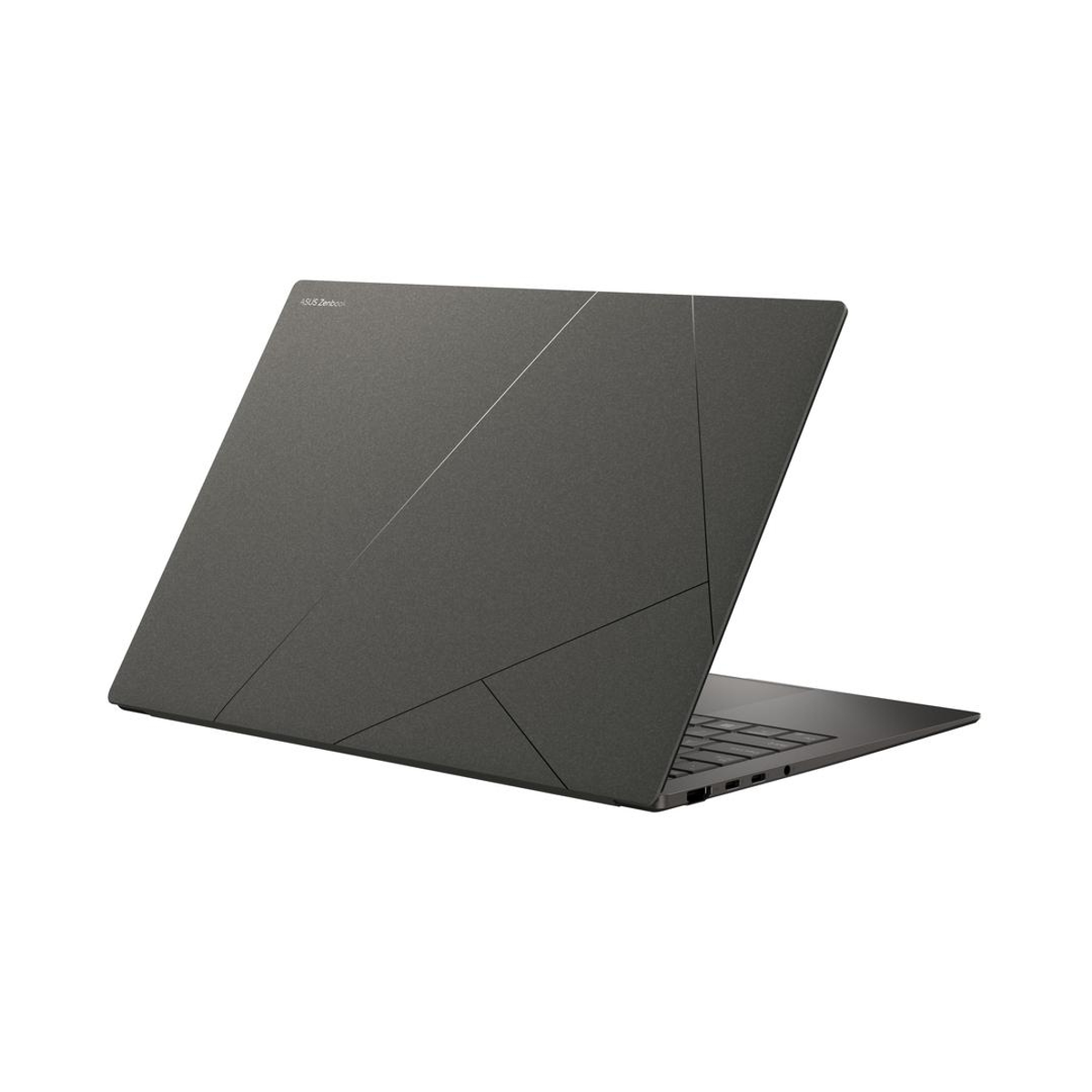 Portátil Asus Zenbook, cerrado. Cubierta gris con diseño geométrico. Teclado negro visible.