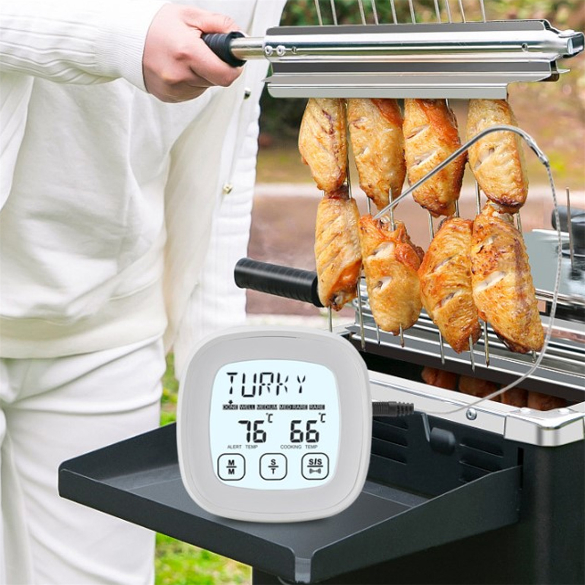 Ein digitales Fleischthermometer zeigt 'TRUTHAHN' mit angezeigten Temperaturen an. Flügel werden oben in einem Grill gegart.