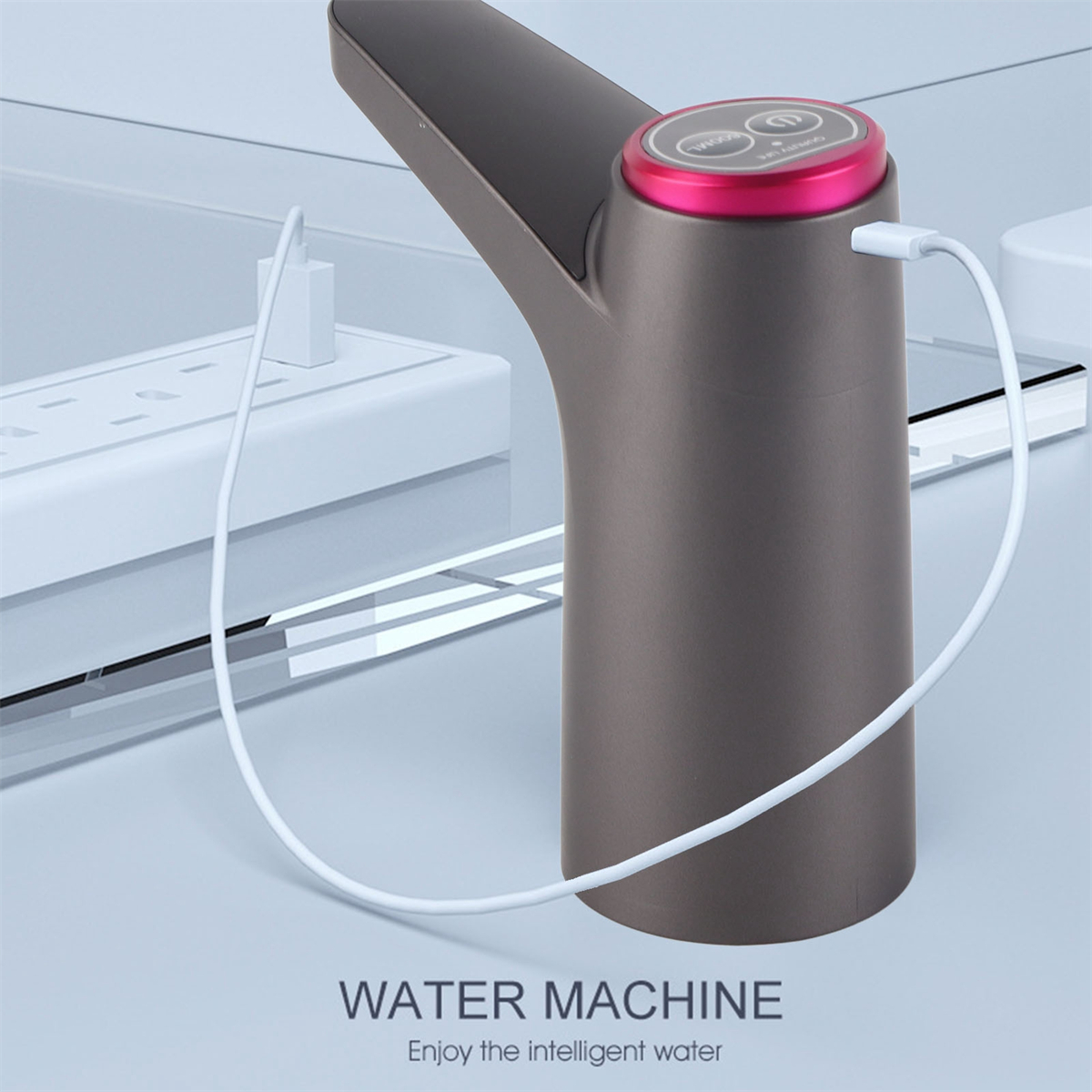 Ein grauer Wasserspender mit rotem Deckel, einem weißen Kabel und einer weißen Steckdose im Hintergrund.