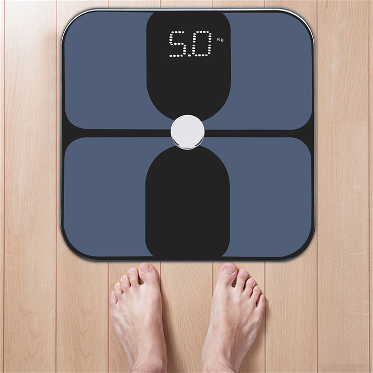 Eine Digitalwaage, die 50 kg anzeigt, mit zwei Füßen darauf, auf einem Holzboden.