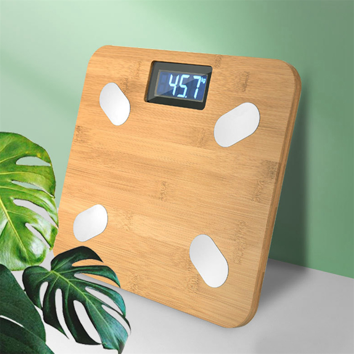 Eine digitale Badezimmerwaage zeigt 45,7 auf ihrem Bildschirm an. Sie ist hellbraun mit weißen Pads.