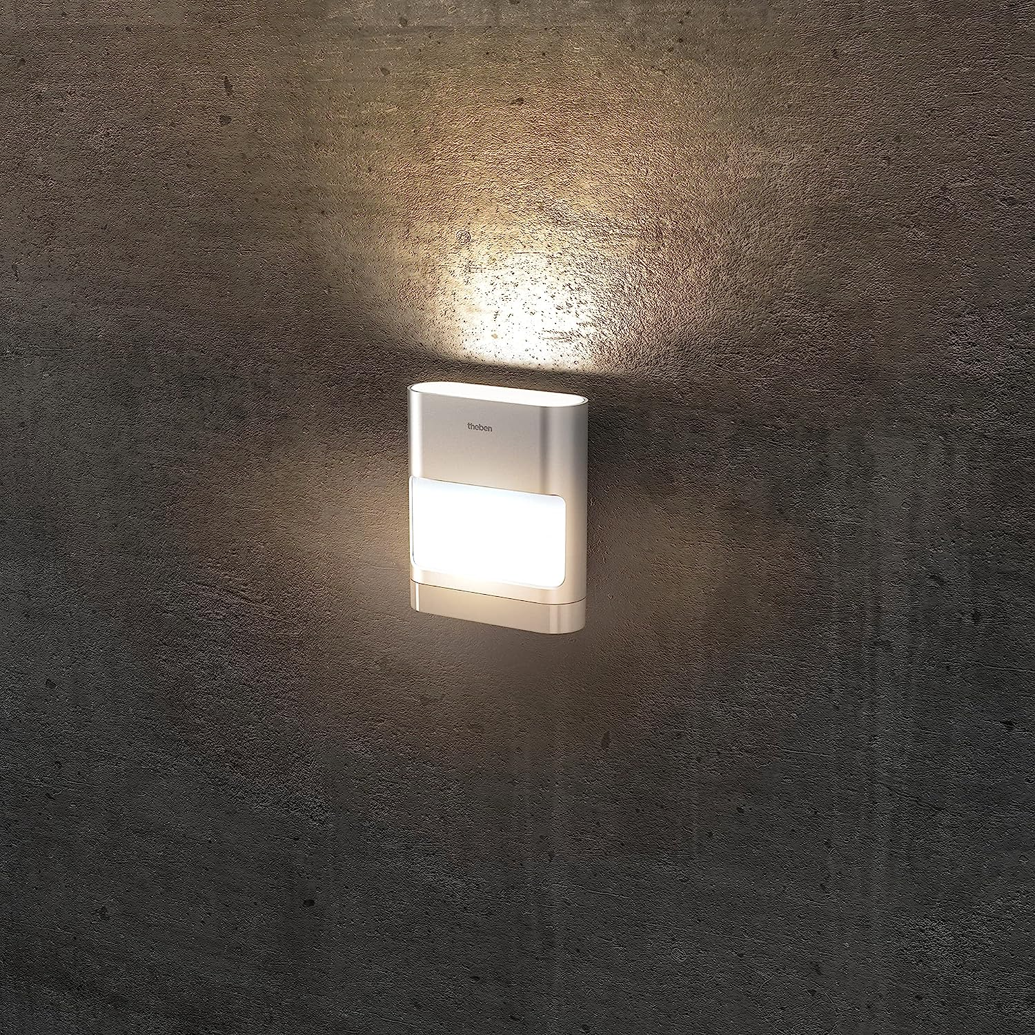 Eine weiße rechteckige Wandleuchte an einer grauen Betonwand. Das Licht ist an und beleuchtet die Wand.