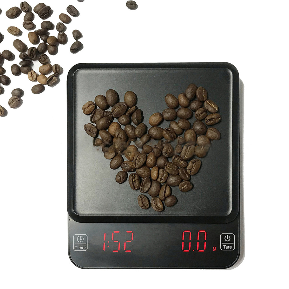 Eine schwarze Digitalwaage mit Kaffeebohnen in Herzform auf weißer Oberfläche.
