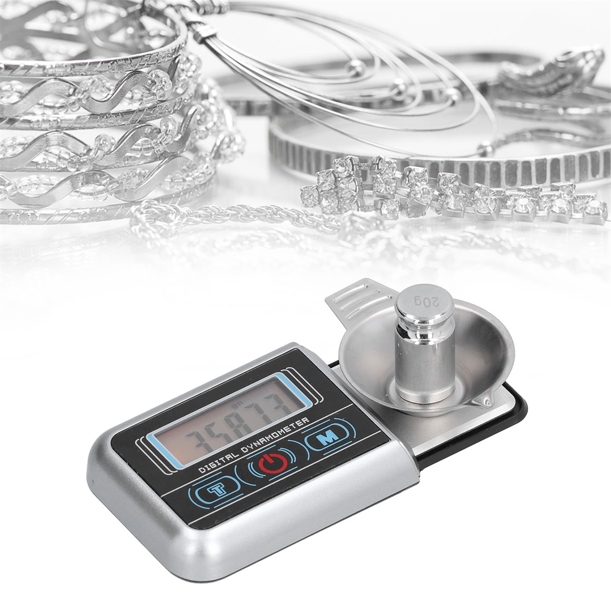 Digitales Dynamometer, silber. Schmuck im Hintergrund, ein Gewicht auf der Waage.