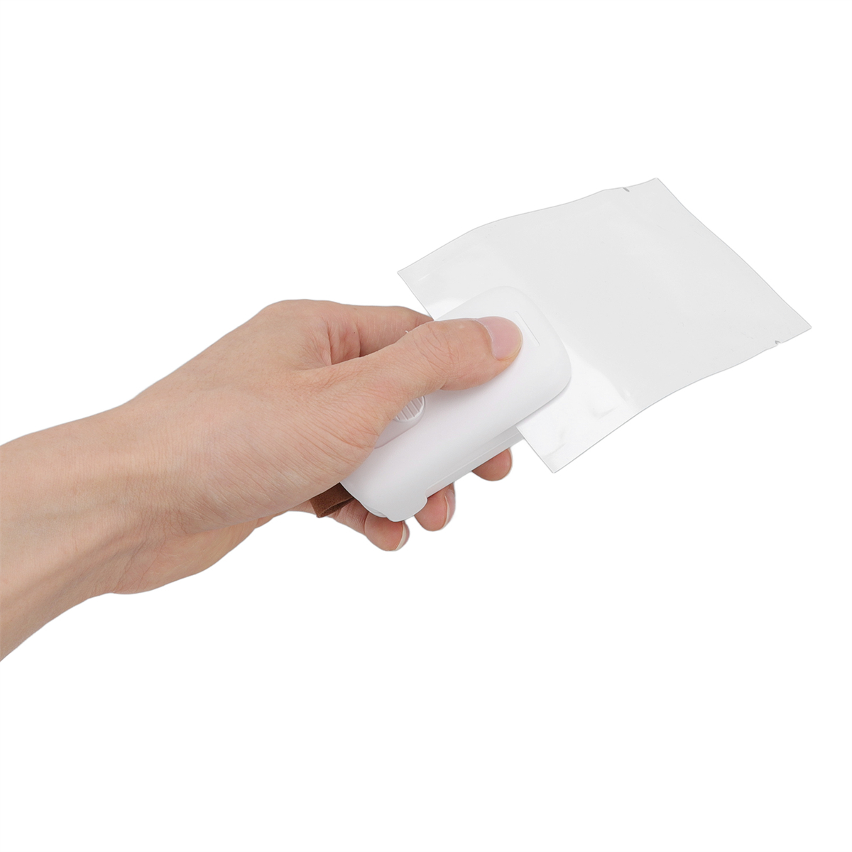 Hand hält ein weißes Siegelgerät und eine weiße Plastiktüte.