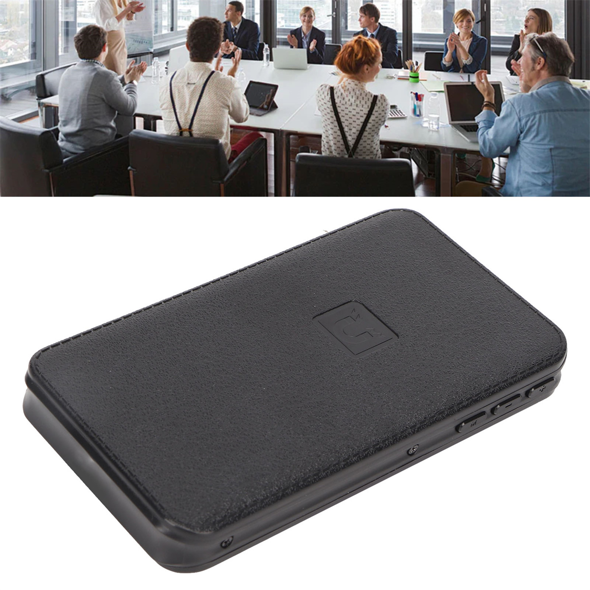 Ein schwarzes Gerät auf einem Tisch, dahinter Menschen bei einer Besprechung. Sie klatschen.