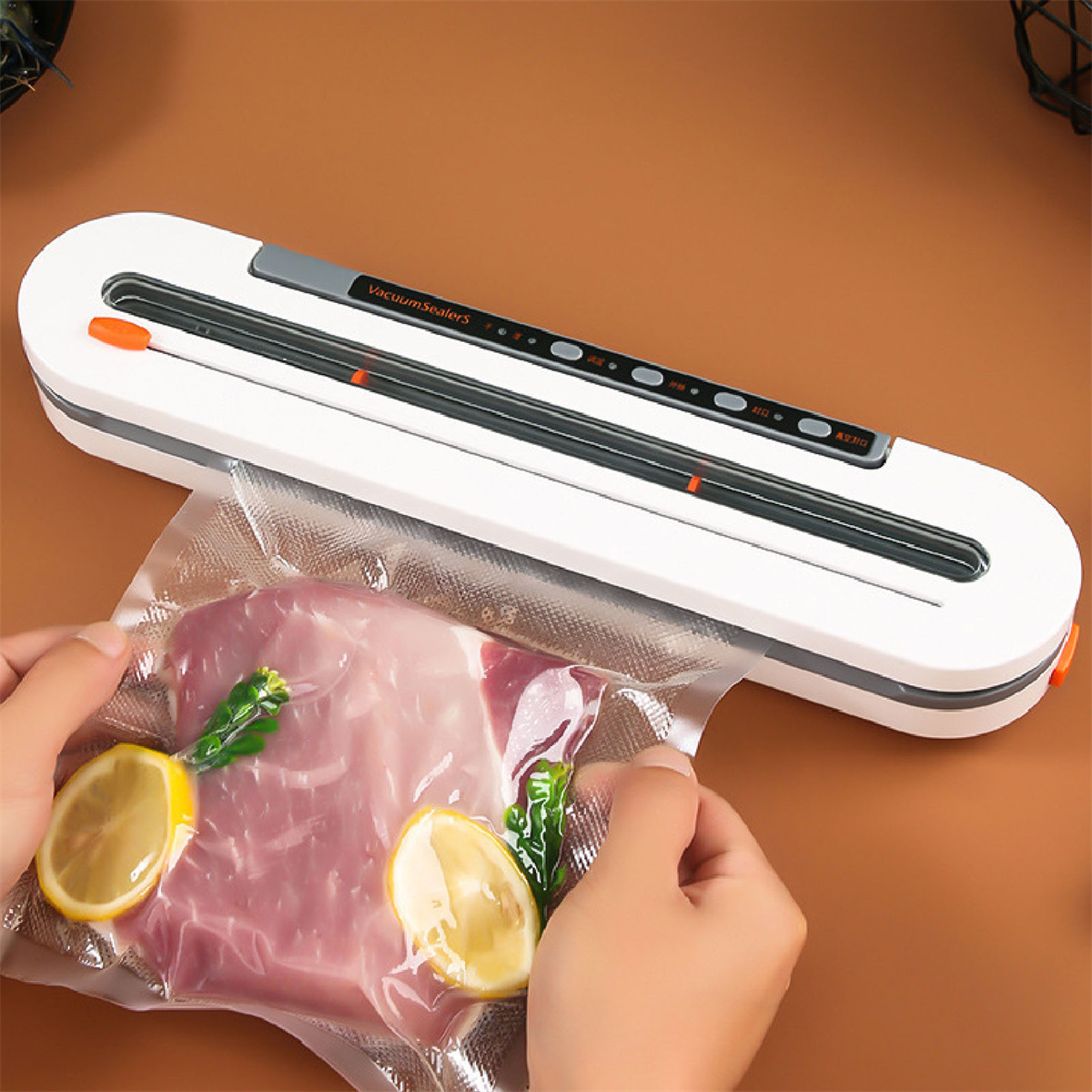 Ein weißes Vakuumiergerät, das einen Beutel mit Fleisch und Zitronenscheiben verschließt. Zwei Hände halten den Beutel.