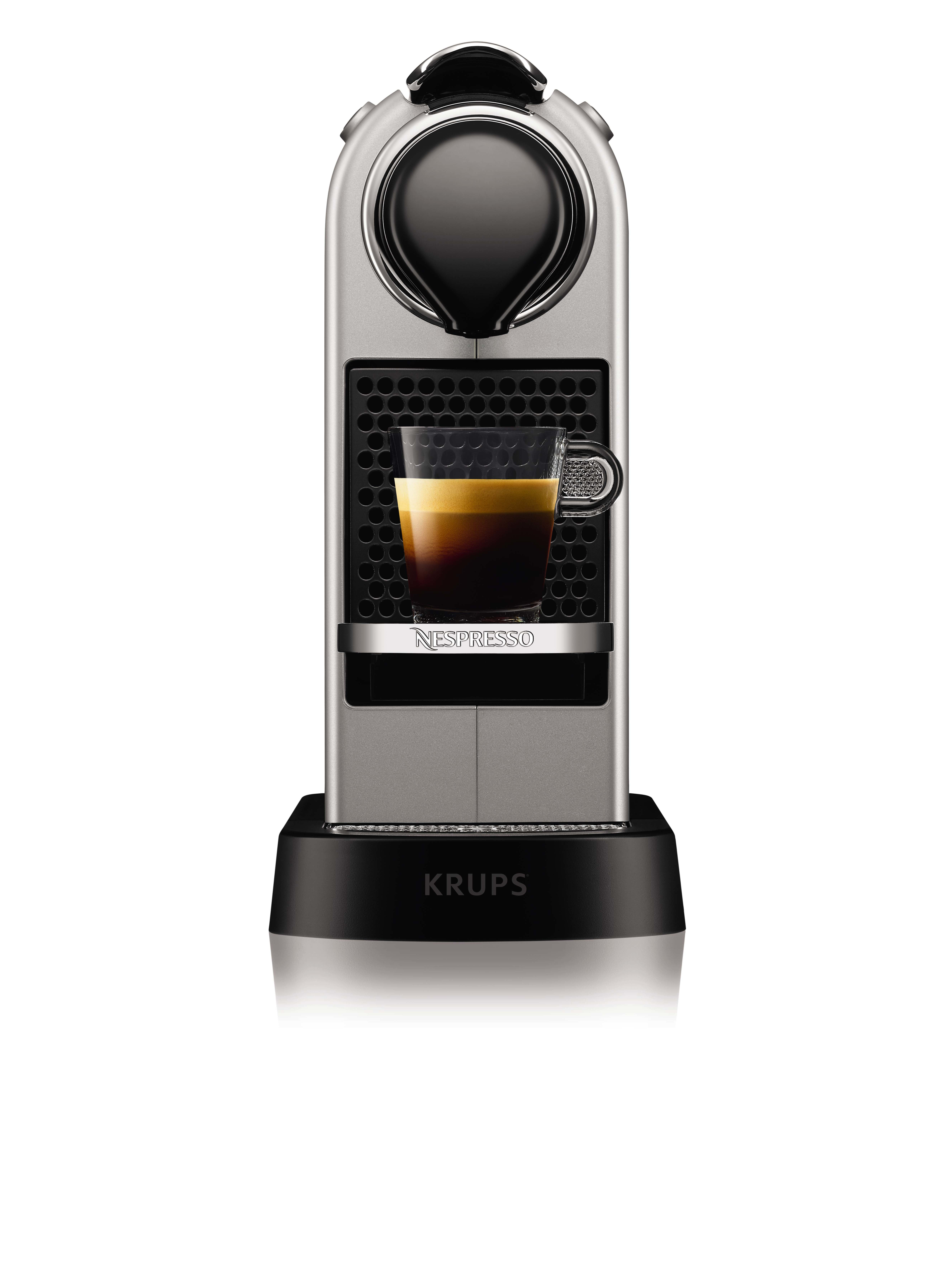 Macchina da caffè Nespresso argento e nero, tazza di vetro con espresso.