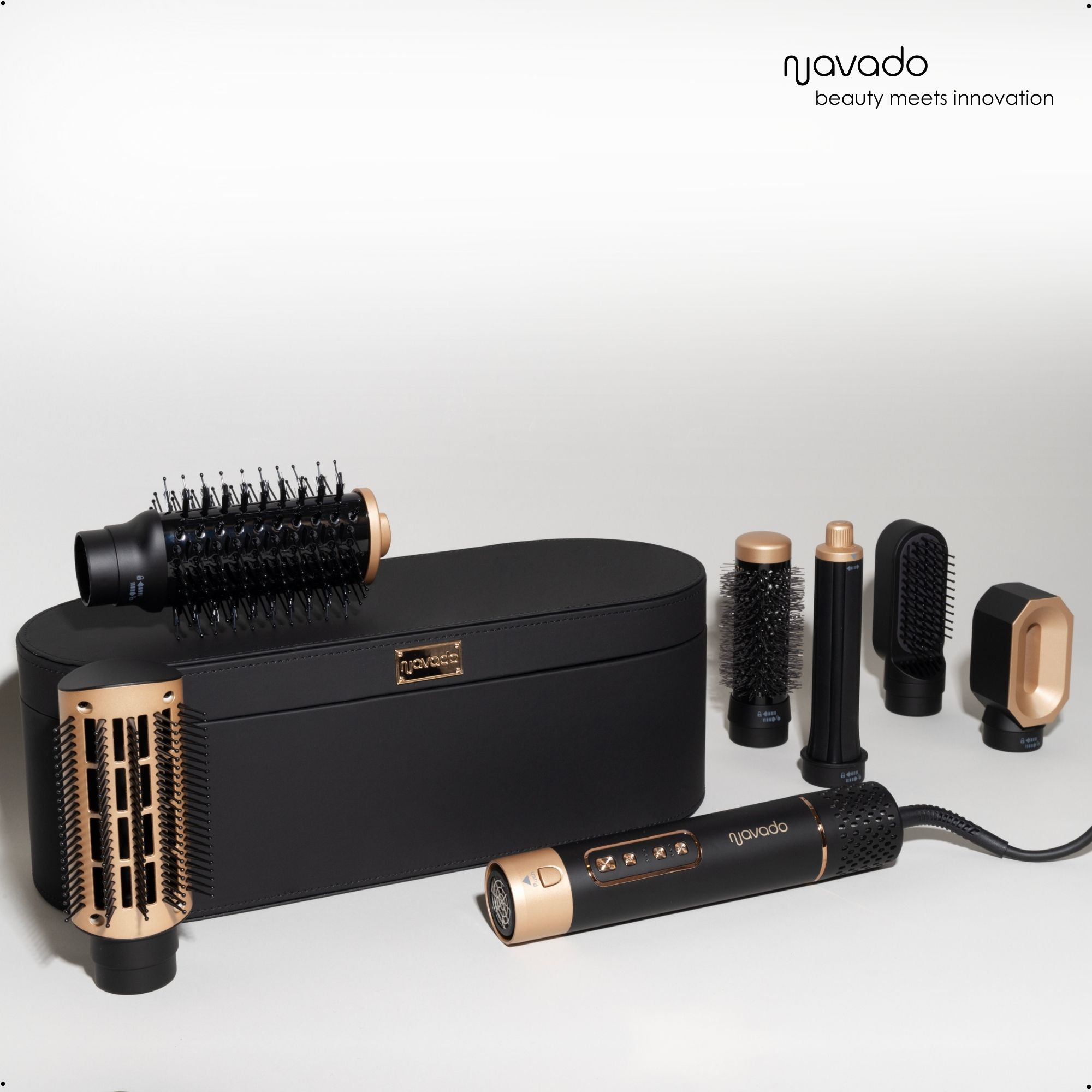 Eine schwarze Tasche mit Haarstyling-Werkzeugen. Ein Haartrockner, Bürsten und Aufsätze. Goldakzente.