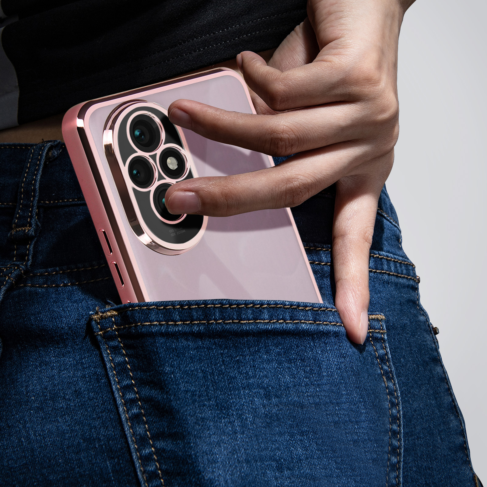 Mano che mette il telefono in tasca. La custodia è rosa e metallica.