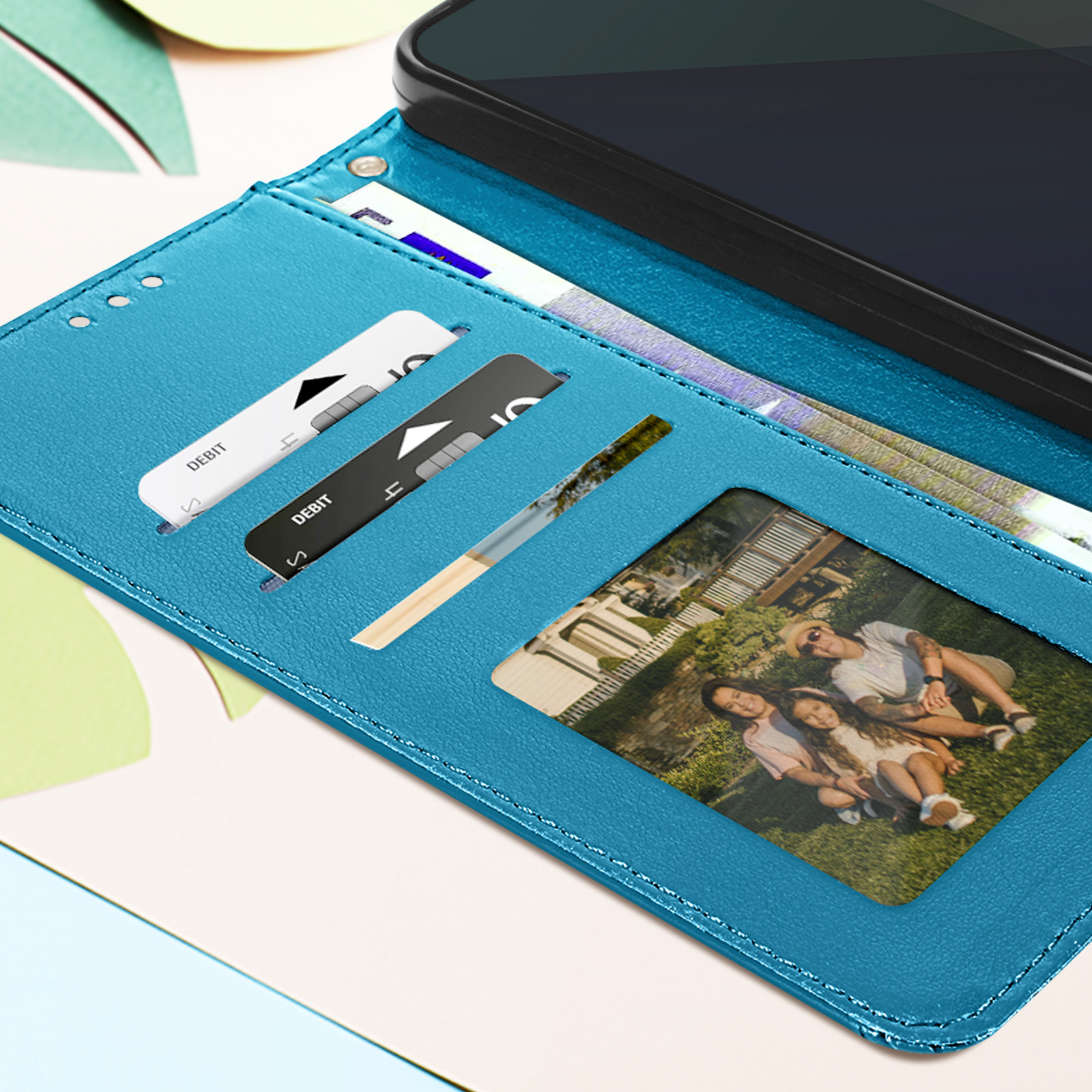 Custodia blu per telefono con carte e foto di famiglia. Il telefono è nero.