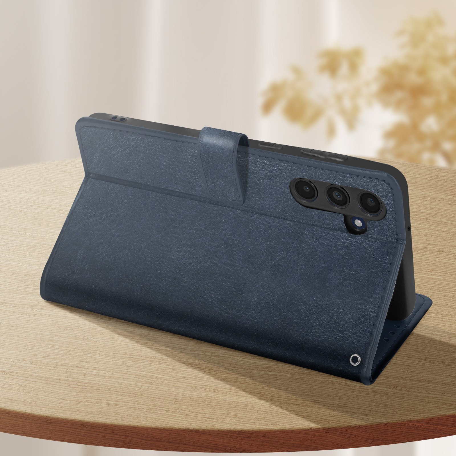 Eine dunkelblaue Handyhülle auf einer Holzoberfläche, mit einem Telefon darin und einem Magnetverschluss.