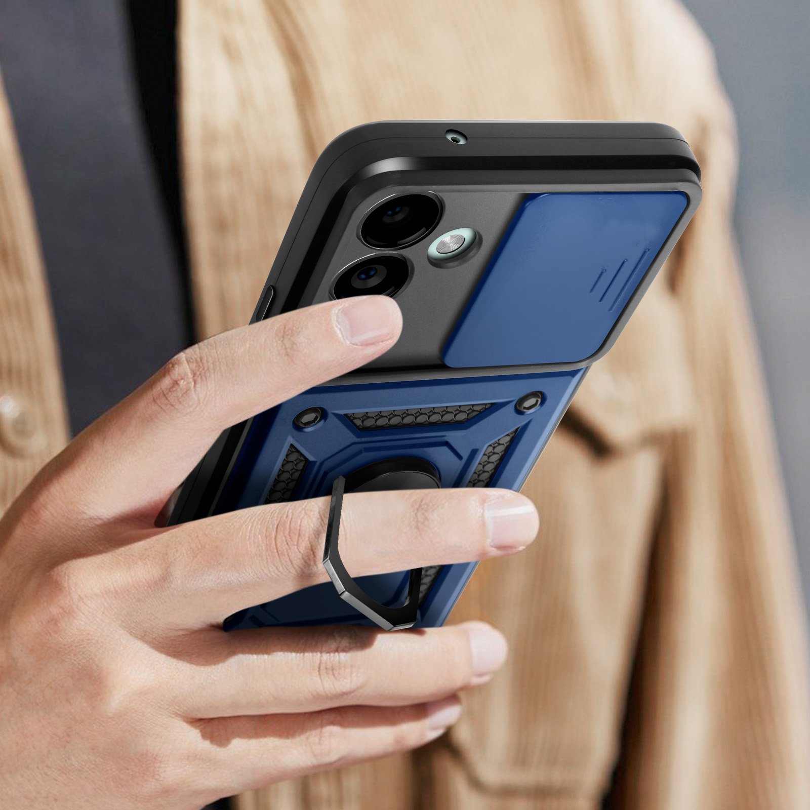 Mano che tiene uno smartphone con una custodia blu. Sono visibili una copertura scorrevole della fotocamera e un supporto ad anello.
