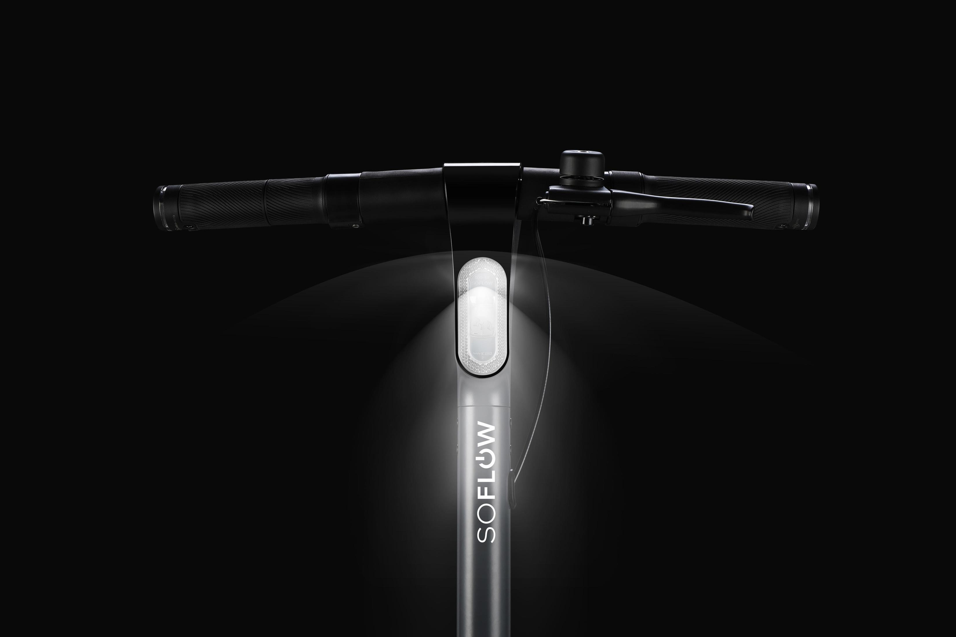 Manubrio dello scooter con una luce intensa. La parola SOFLOW è visibile sullo stelo dello scooter.