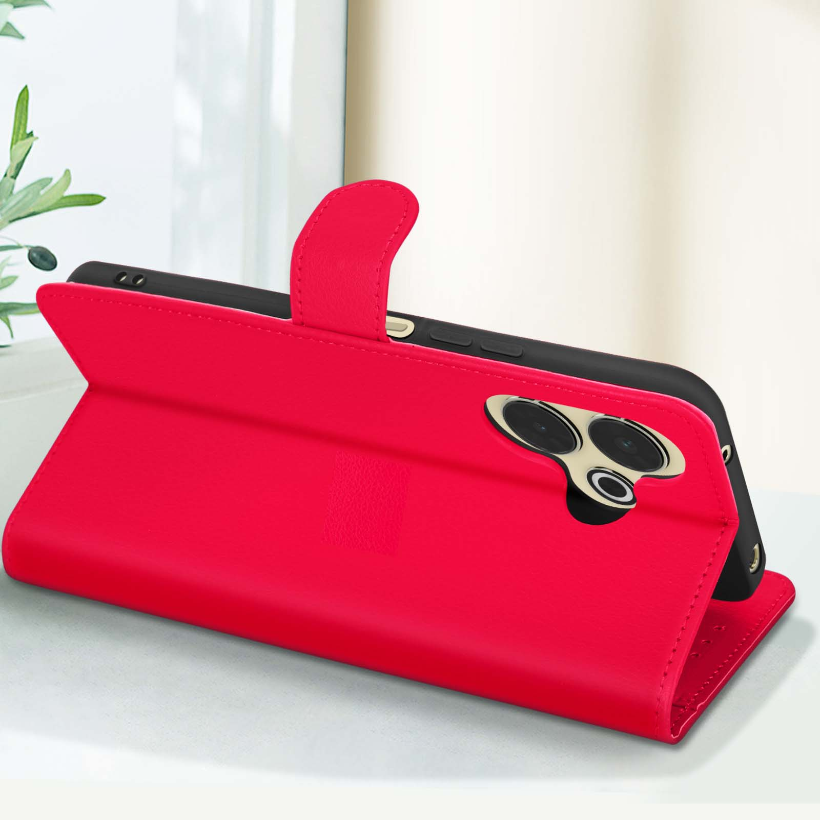 Custodia per telefono rossa aperta, con un telefono nero. Copertura rossa con telefono nero.