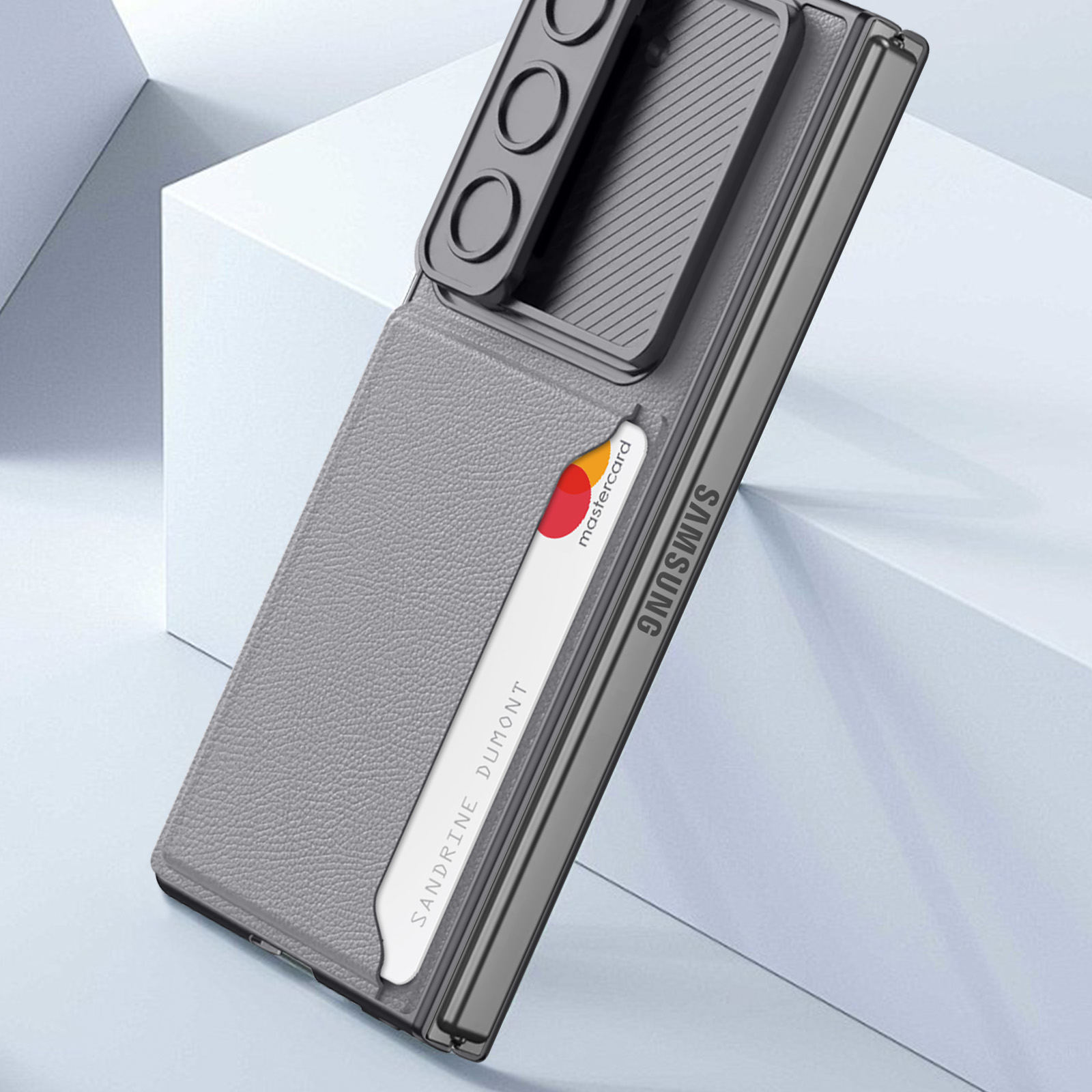 Custodia grigia per telefono con porta carte e ritaglio per fotocamera. La custodia è su una superficie bianca.