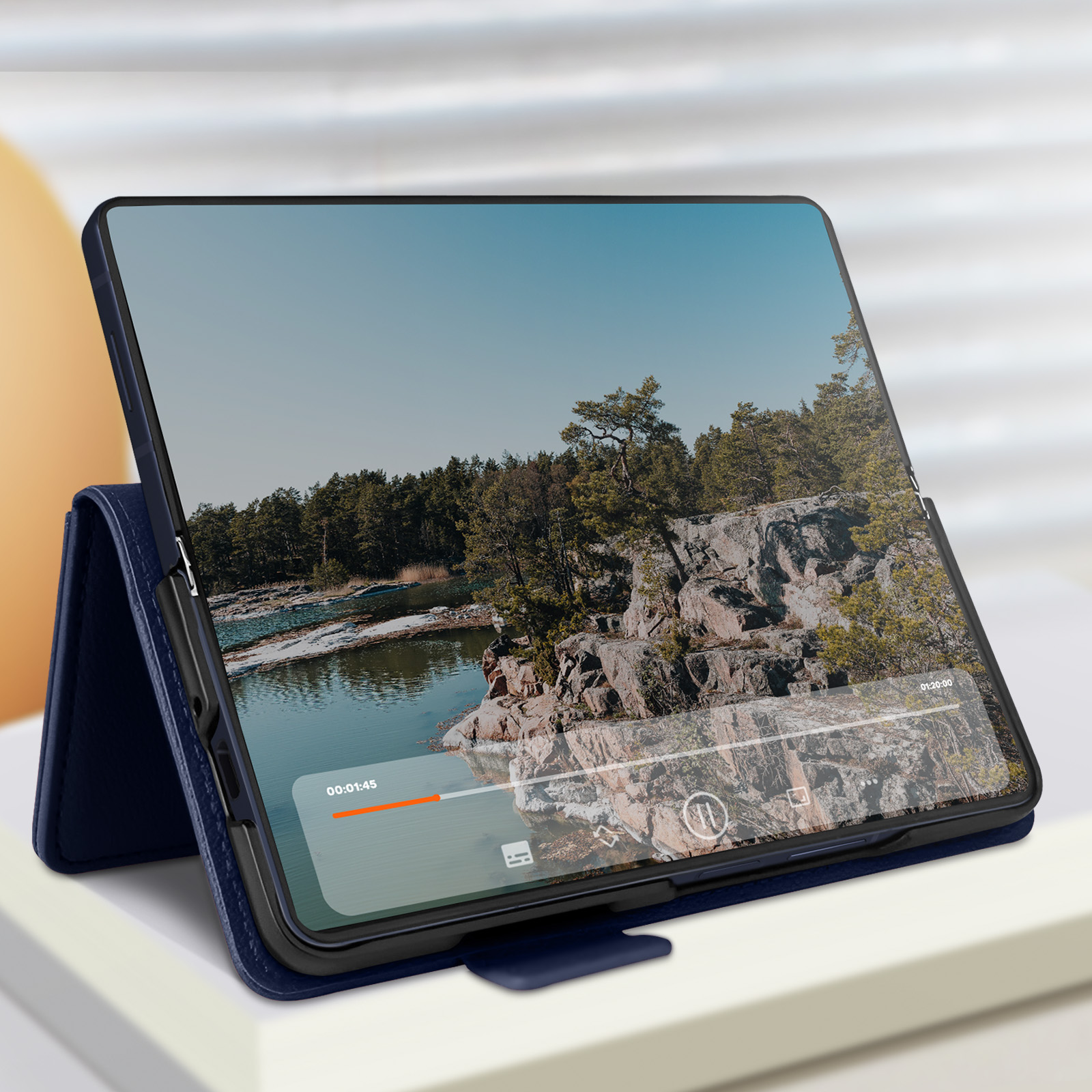 Tablet in una custodia blu. Vista della foresta con lettore multimediale. Lo schermo mostra un video.