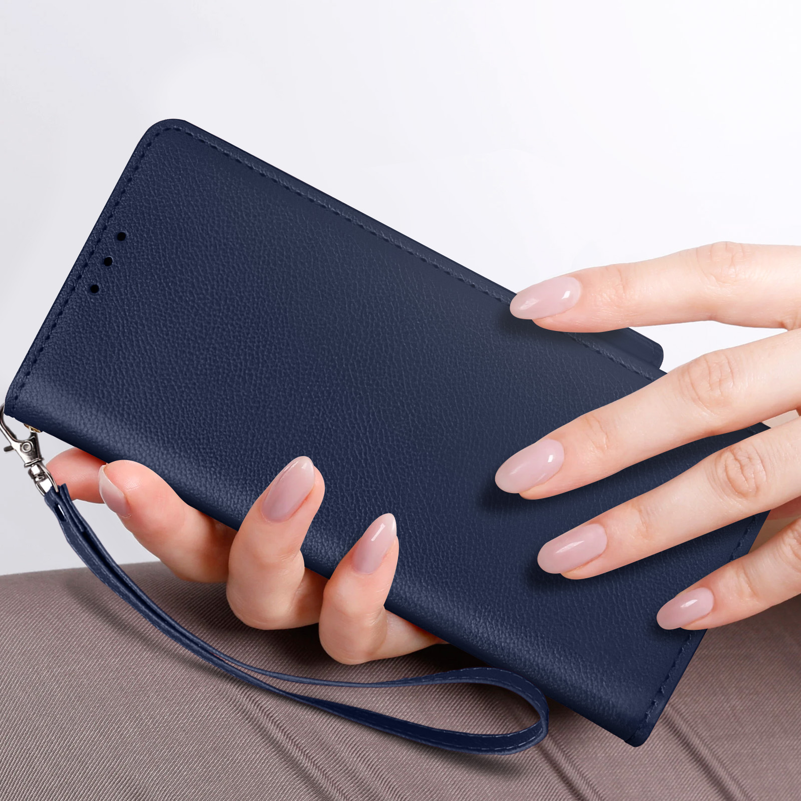 Una custodia per telefono blu navy tenuta da una mano con unghie curate.