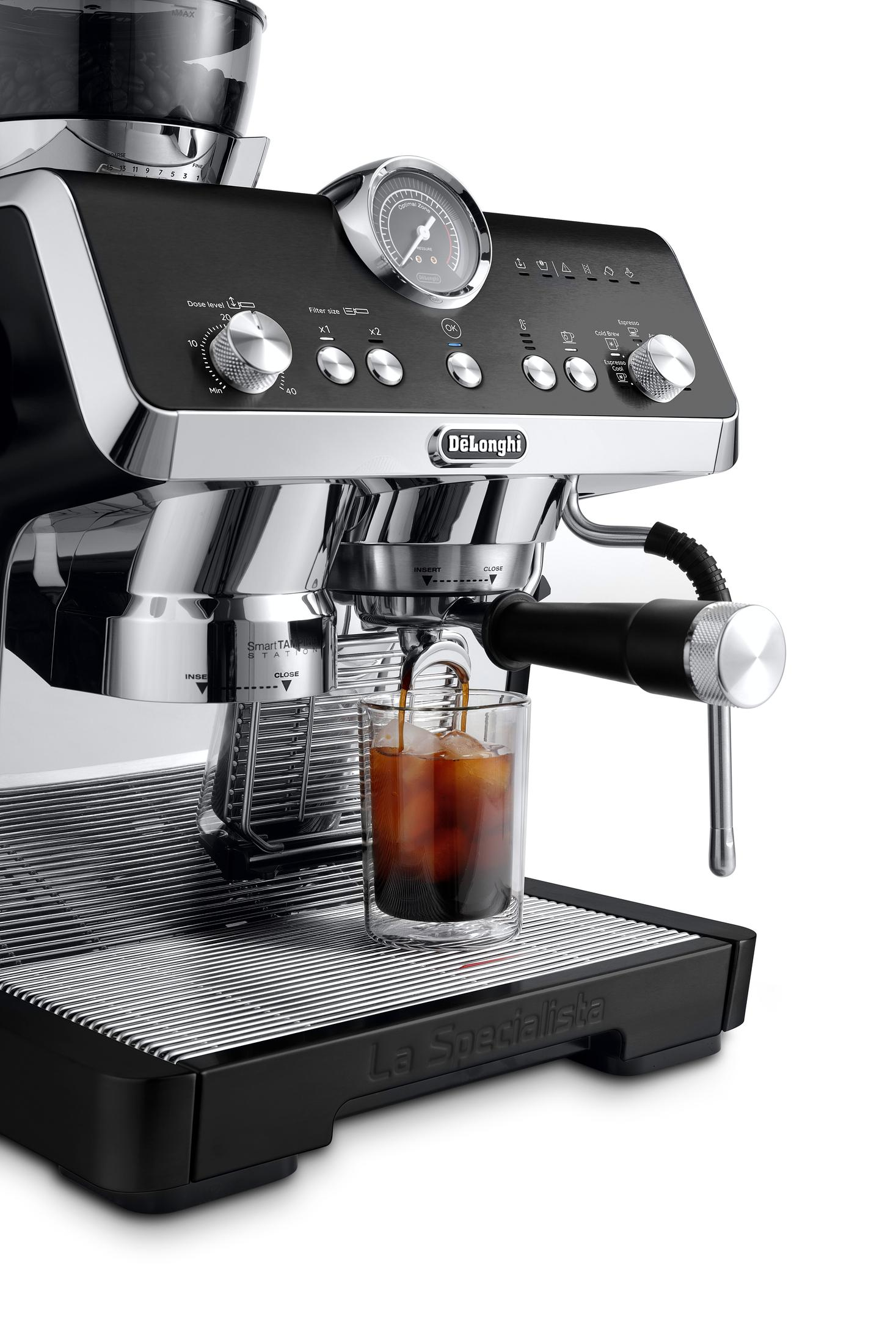 DeLonghi espressomachine die koffie in een glas maakt, op een wit oppervlak.